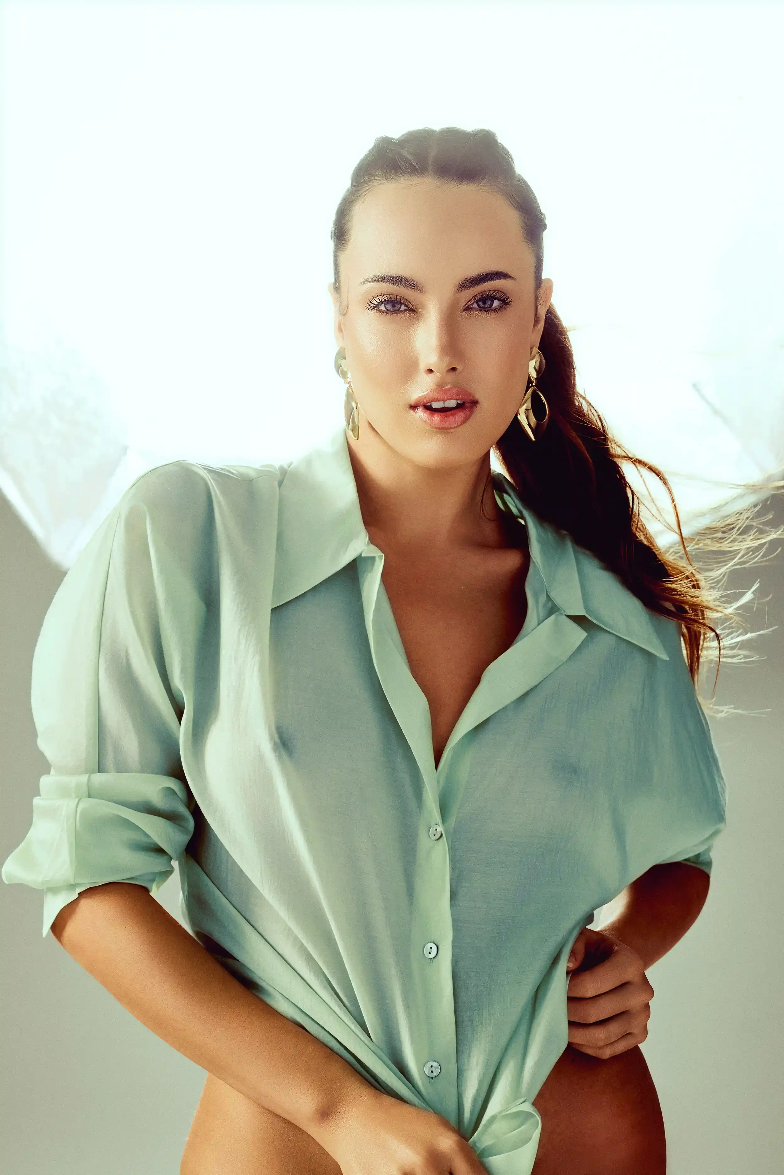 A woman wearing a light green shirt, with her hair in a ponytail, is posing with a relaxed expression. Anandclix, Bangalore, advertising photographer, Fashion photographer, Editorial photographer, Bangalore photographer.