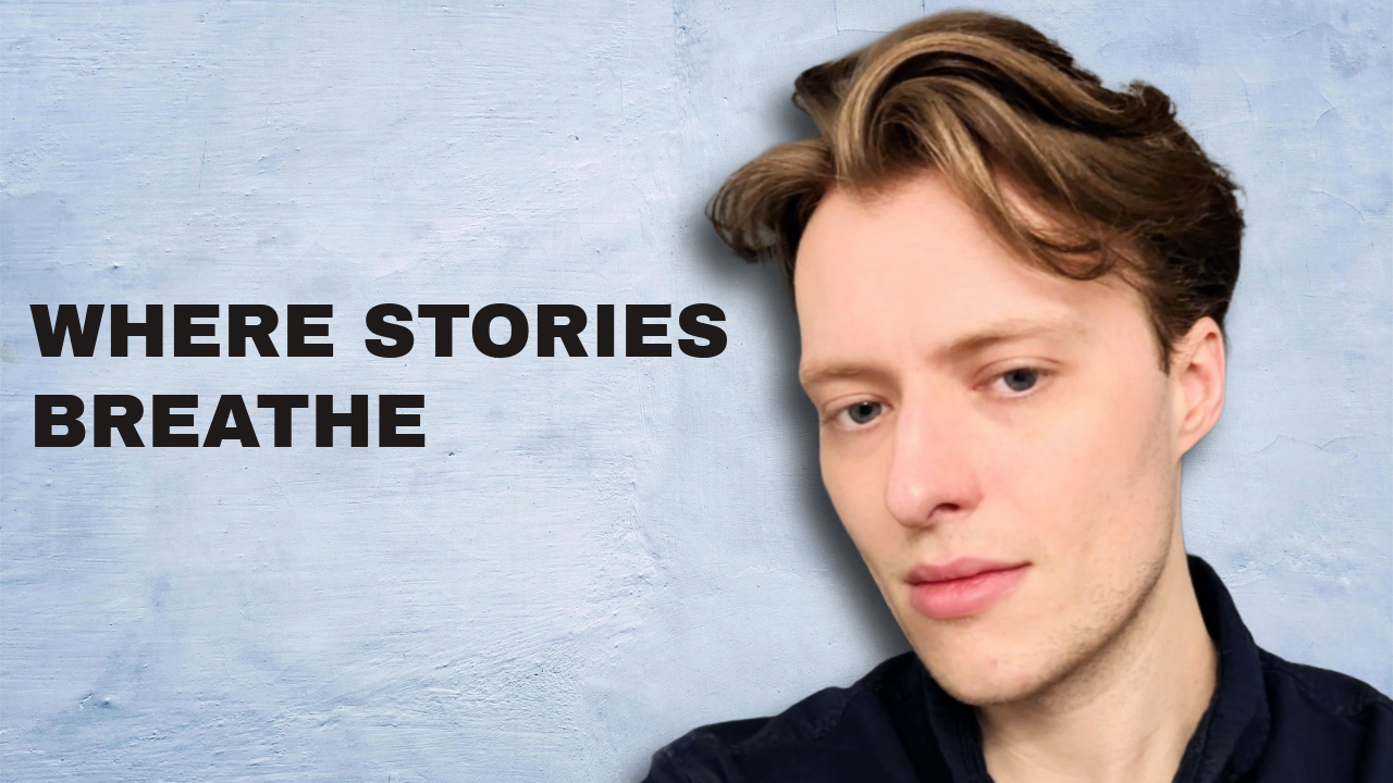 A young man with light brown hair and a slight smile, standing against a textured blue background with the text 'WHERE STORIES BREATHE' written in bold black letters to the left of him.