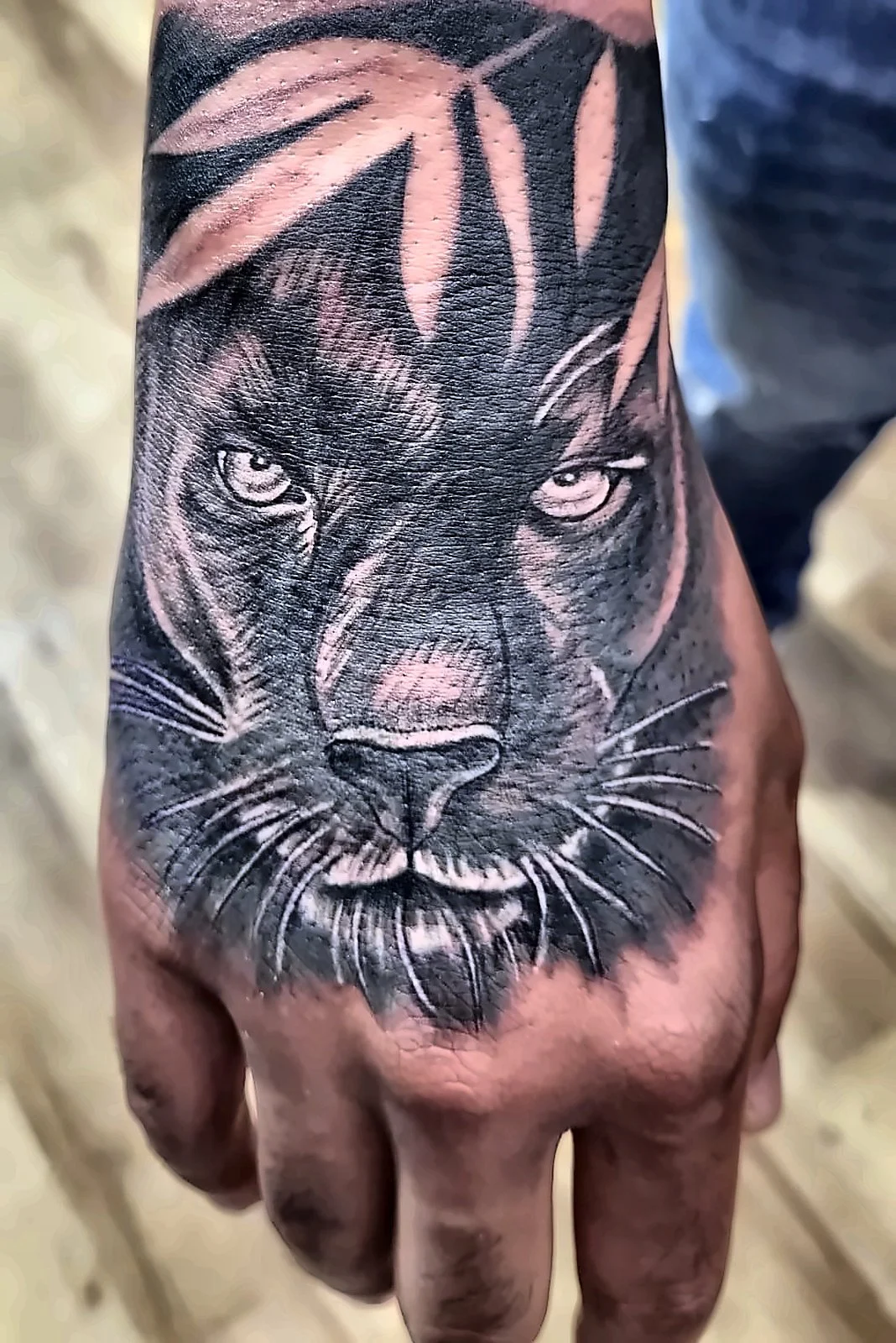 Black and Grey Tattoo Offenbach: schwarzer Panther mit Blättern auf dem Handrücken, King Tattoo