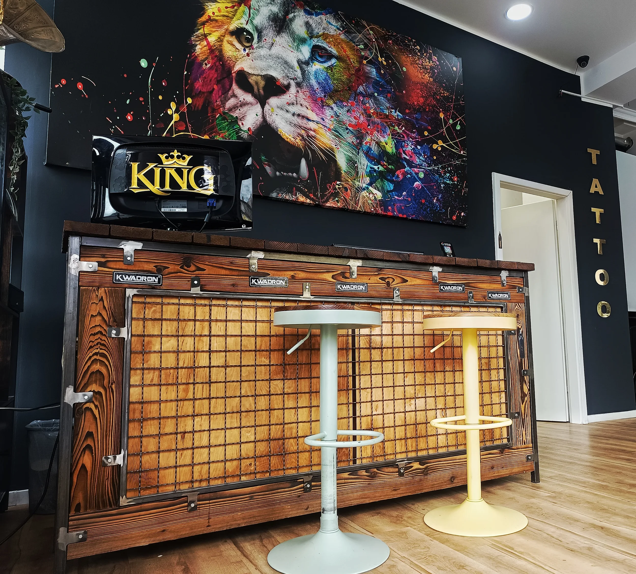 Empfangstheke im King Tattoo Studio Offenbach mit Wandbild eines bunten Löwen und King-Logo