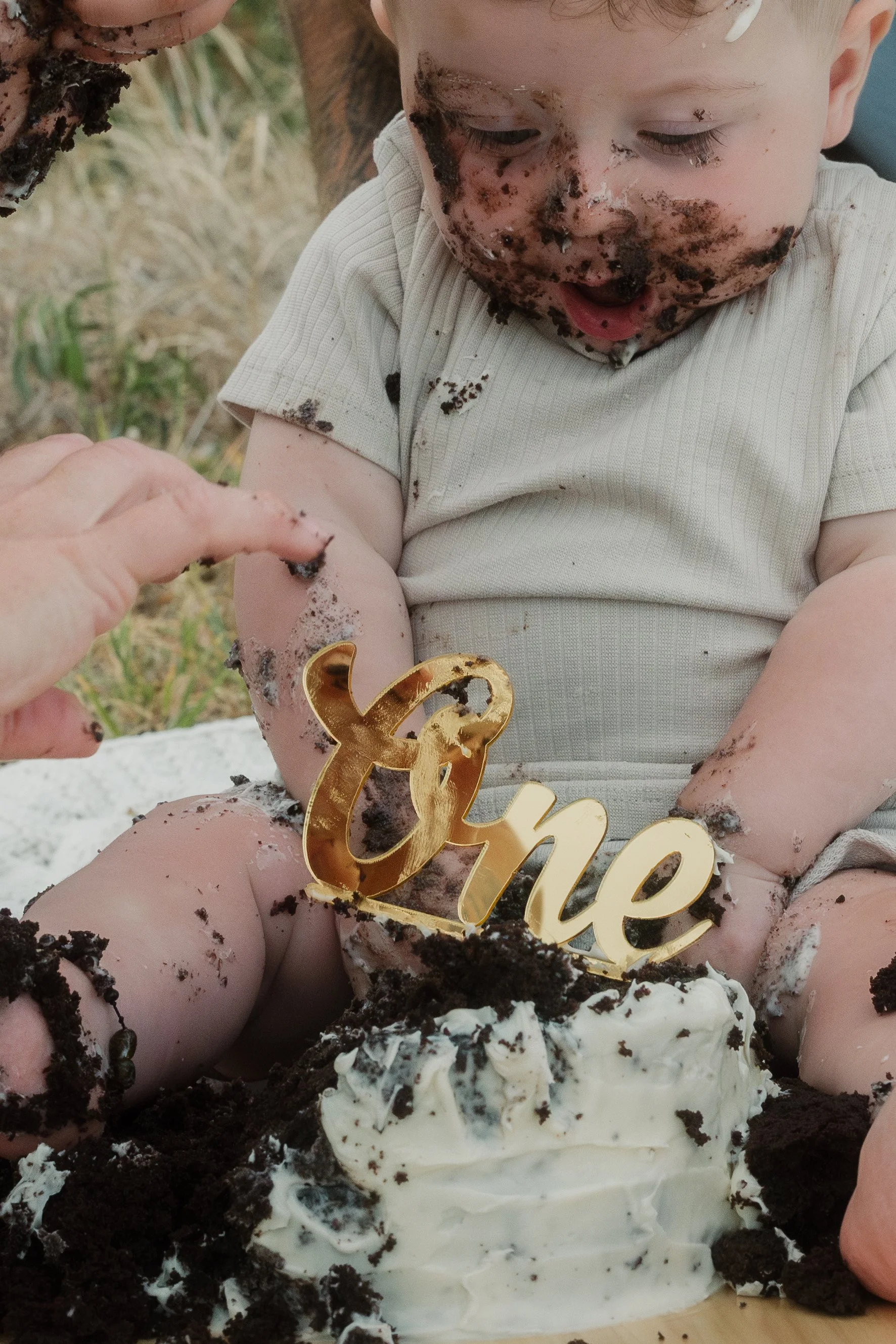 baby sitting with cake during first birthday cake smash photography session