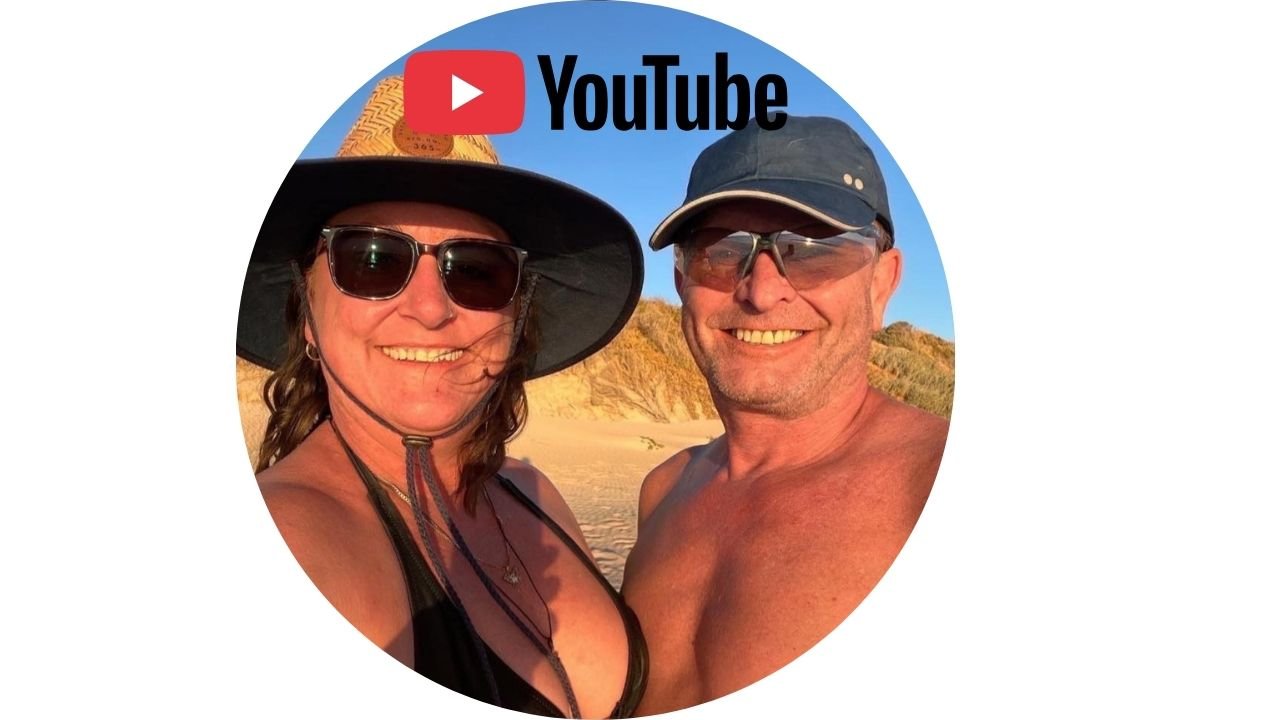 Two smiling people wearing sunglasses and hats on the beach, with a sunset and sand dunes in the background, and a YouTube logo at the top.