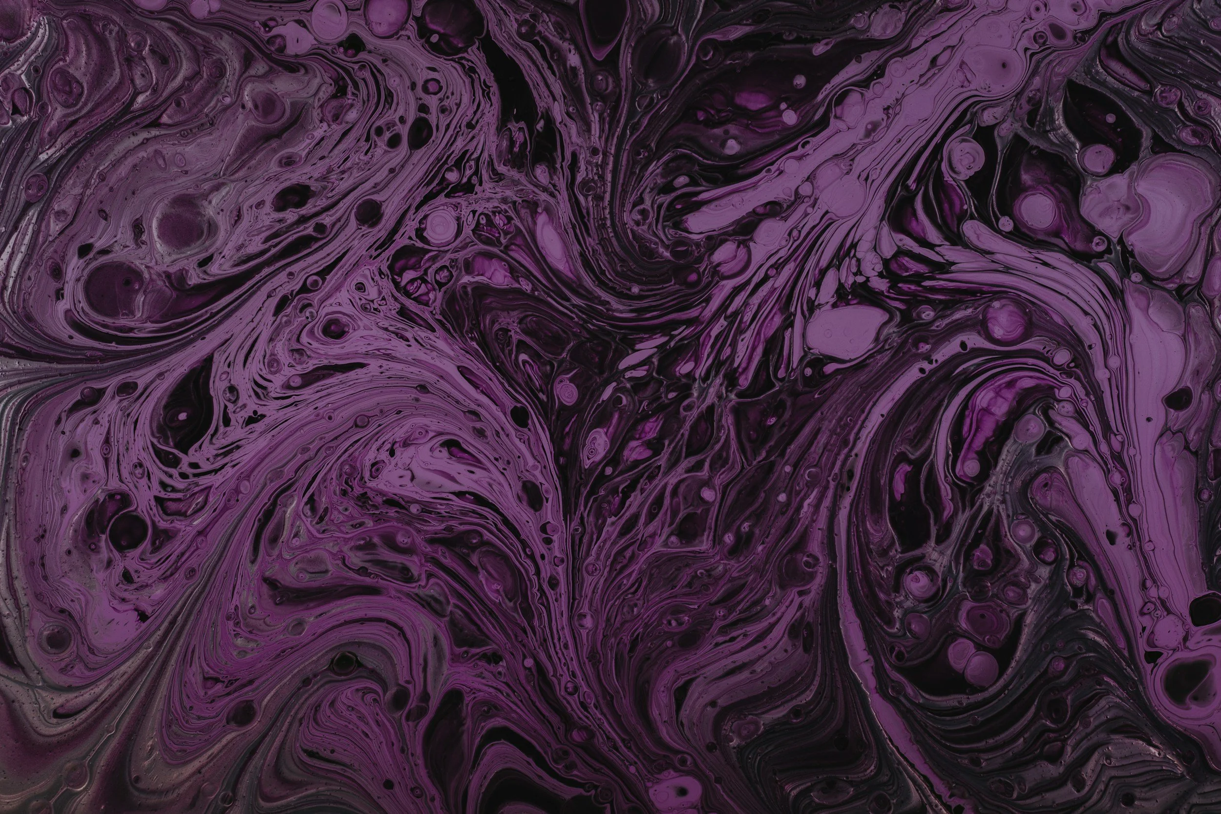 Marbled pattern with shades of purple, black, and gray, featuring swirling and bubbly textures.