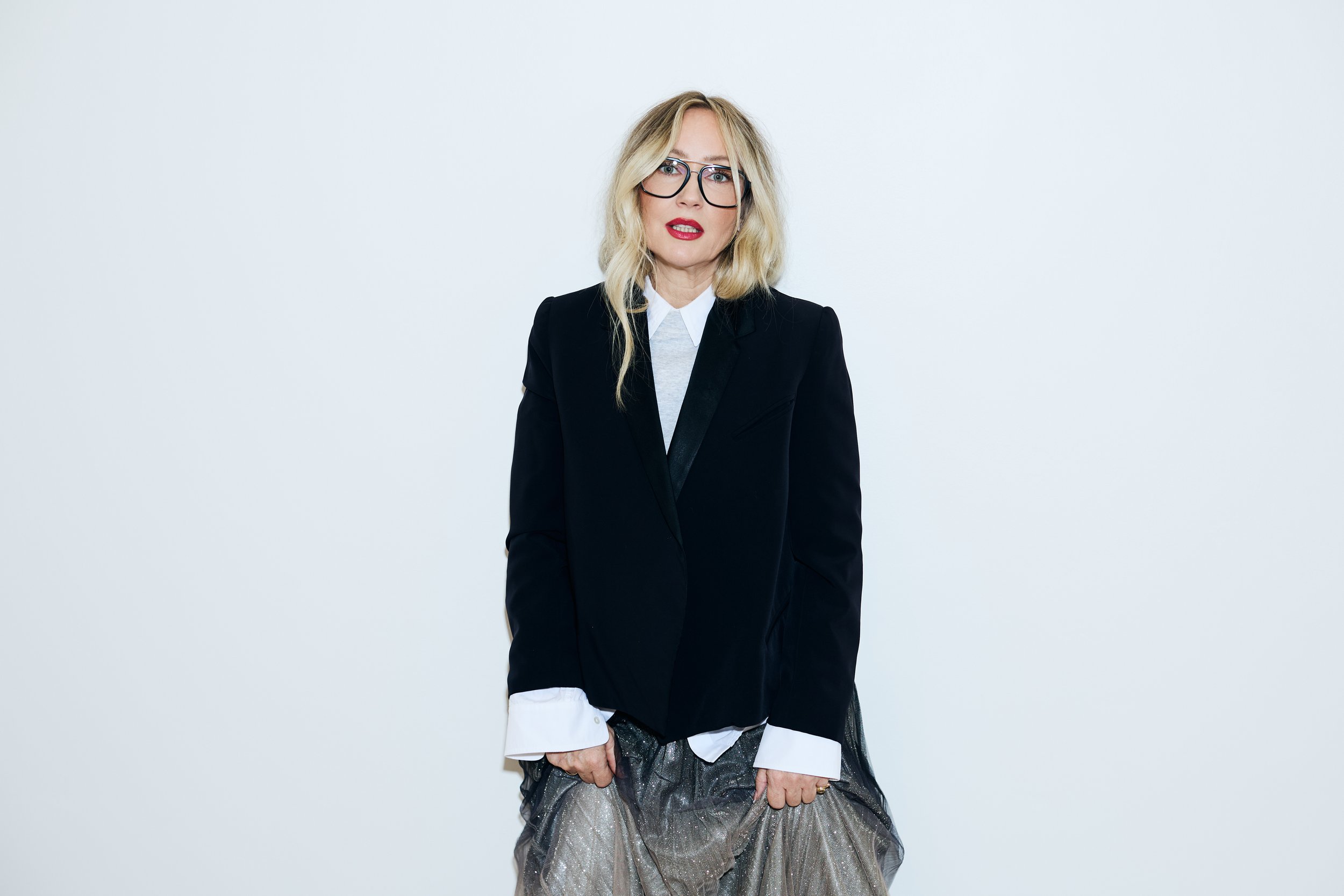 Danielle Butcher in a black blazer and red lip, standing confidently for the Red for a Reason campaign