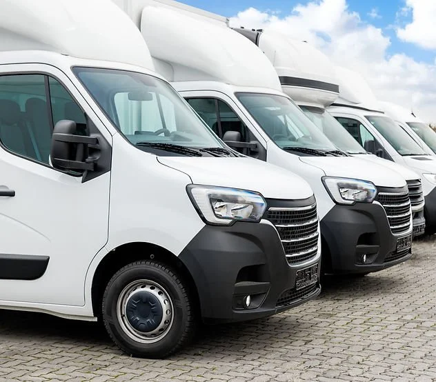 Row of white Luton box vans parked side by side