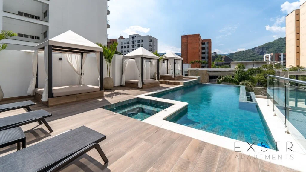 Luxury rooftop pool area with cabanas, lounge chairs, and cityscape view.