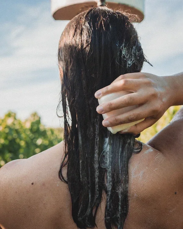 mulher cabelo liso sendo lavado ao ar livre