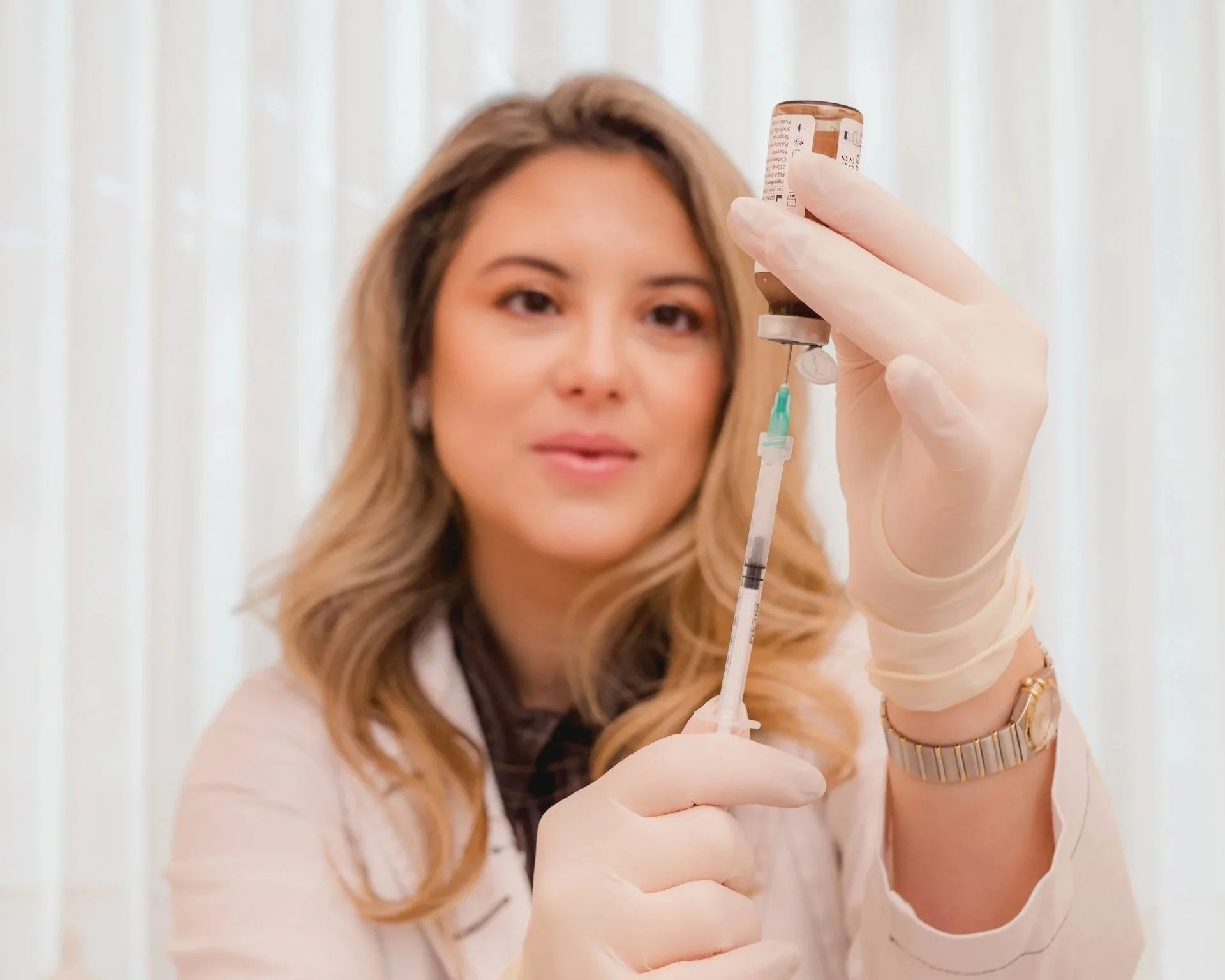 Médica enchendo agulha de procedimento estetico