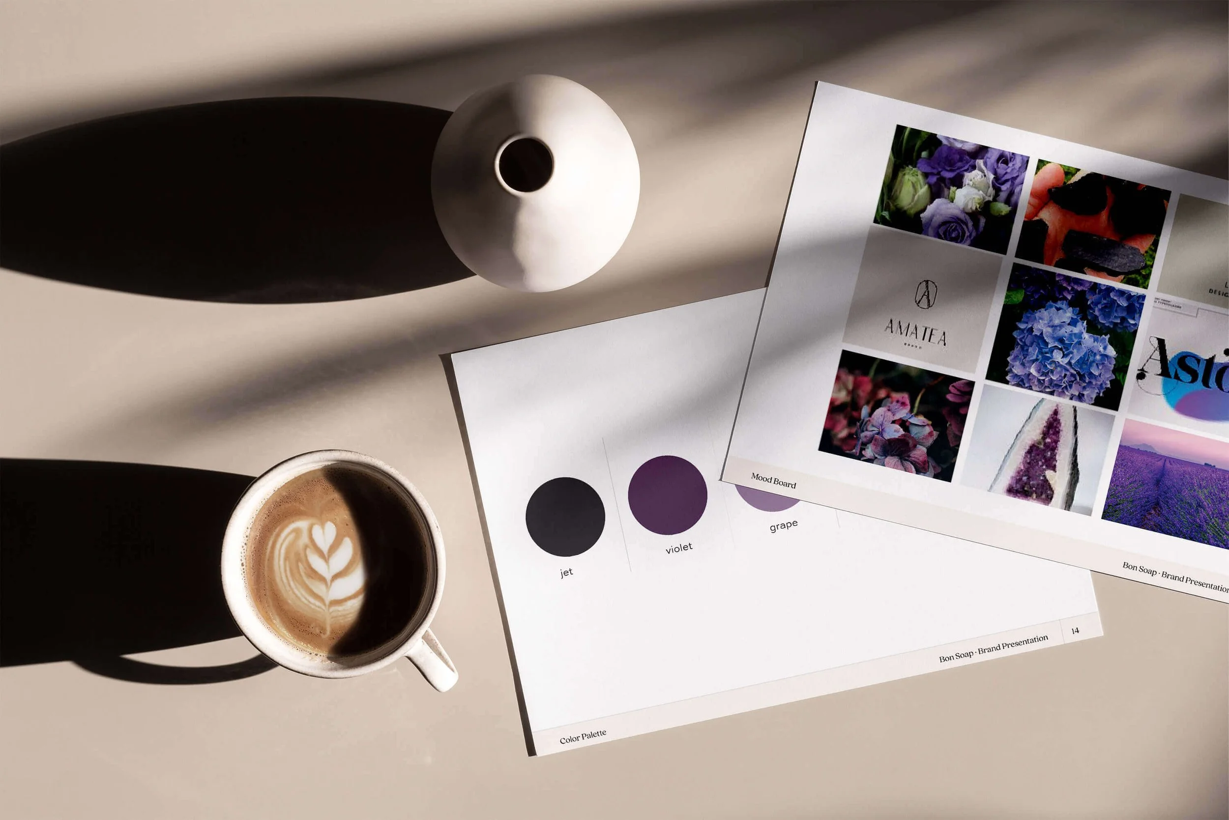 A coffee cup next to a purple card featuring a photo of a brand board