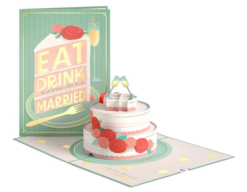 A wedding cake decorated with pink and red roses and green leaves, topped with two champagne glasses. The cake is on a decorated mat with yellow hearts, and a wedding card with the words 'Eat, Drink, Be Married' in the background.
