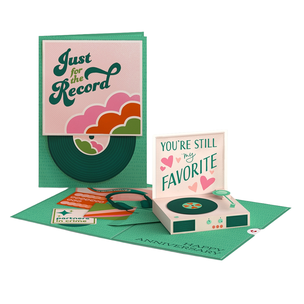 A pop-up birthday card scene featuring a record player with a sign that says 'You're still my favorite' and other cards and decorations around it.