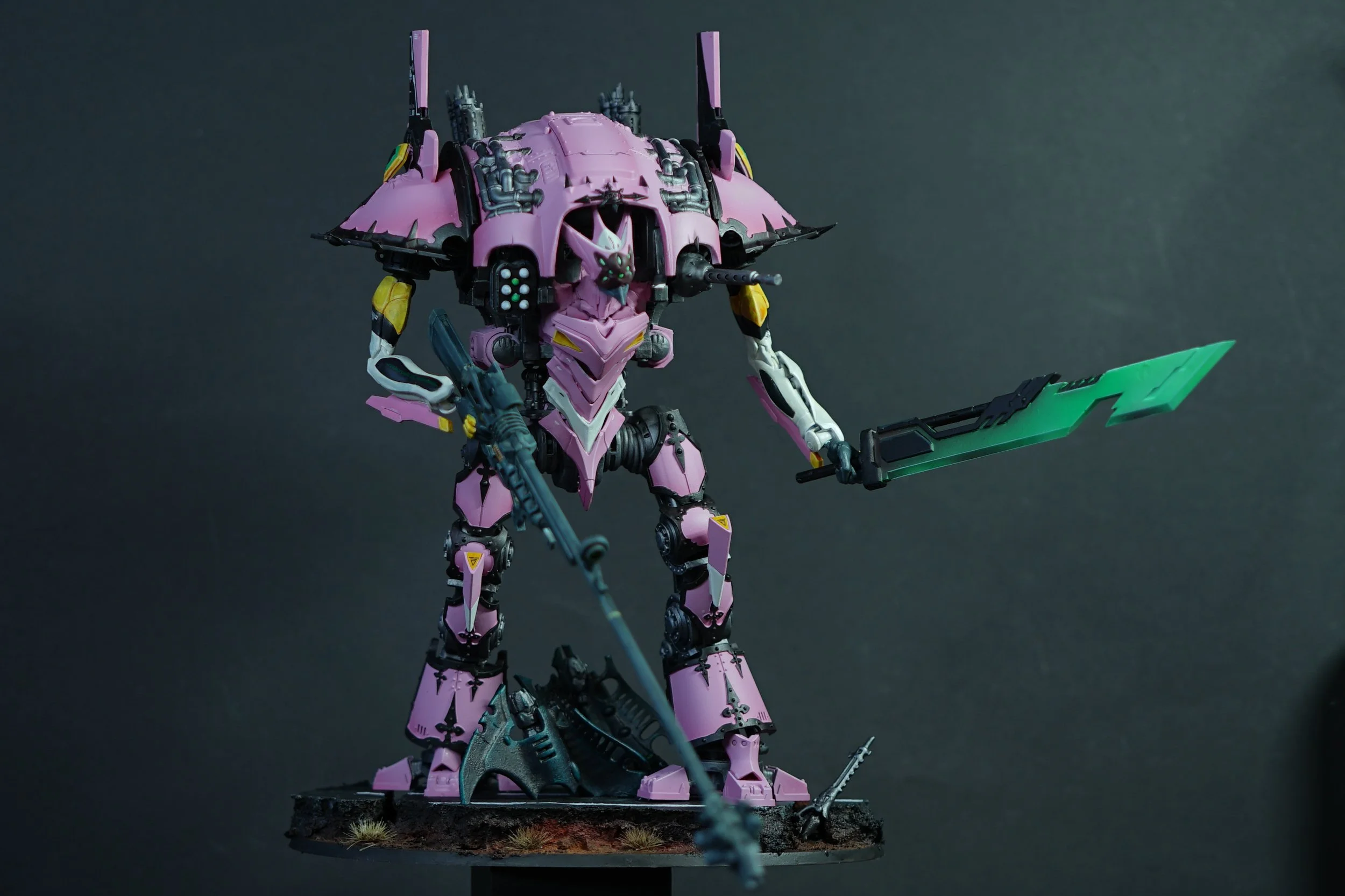 A detailed model of a pink and black robot with a green sword, standing on a textured base with grass and debris, against a dark background.