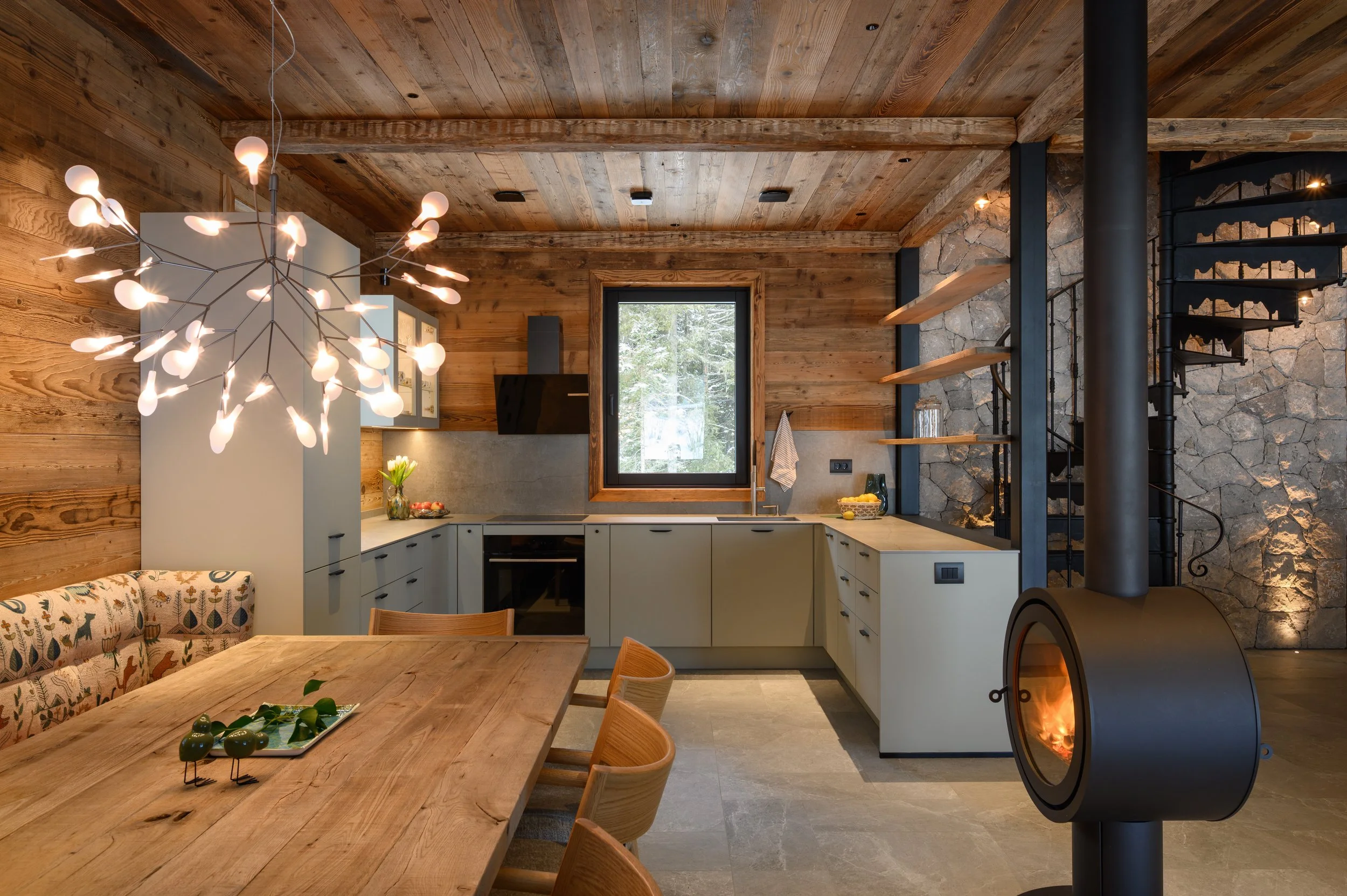 Dining room kitchen interior with tunnel fireplace, mountain chalet Julian Alps