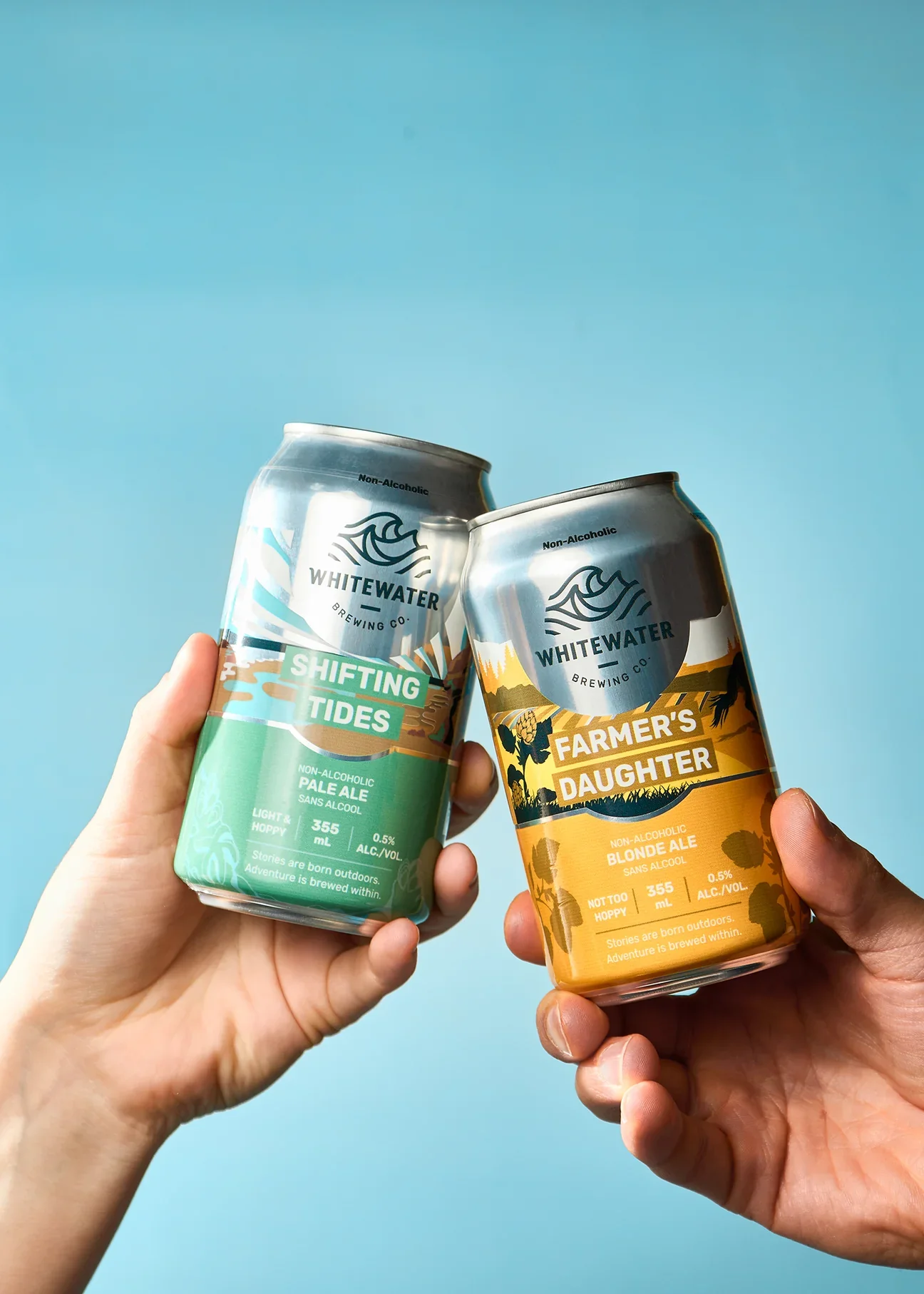 An image of hands holding drinks from Whitewater Brewing Co