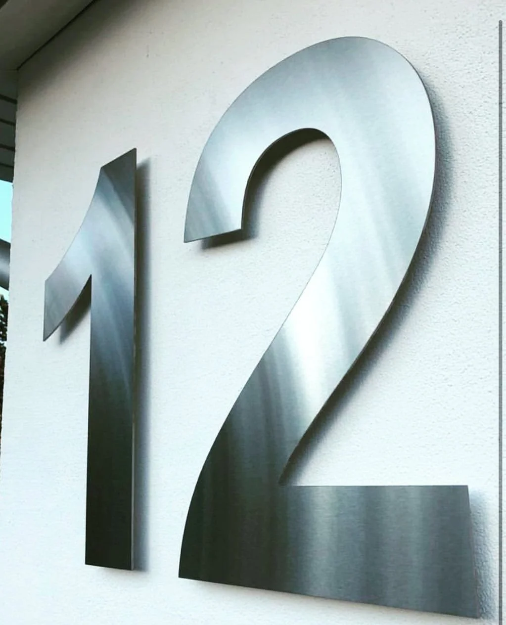 Husnummer 12 i spiegelpolerat rostfritt stål – exklusiv närbild