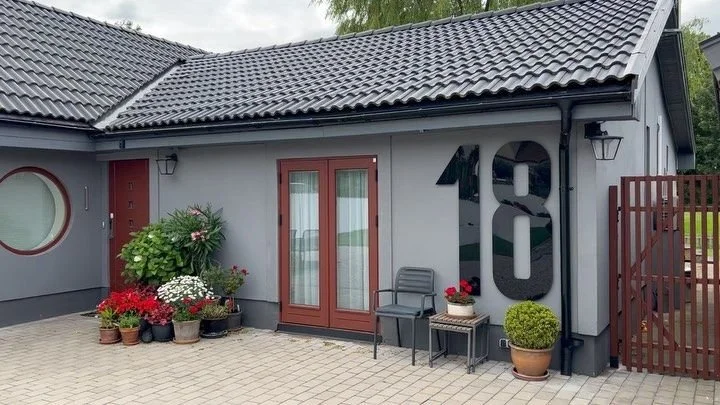 Stora svarta husnummer 18 i svart akry på villa – mysig husexteriör