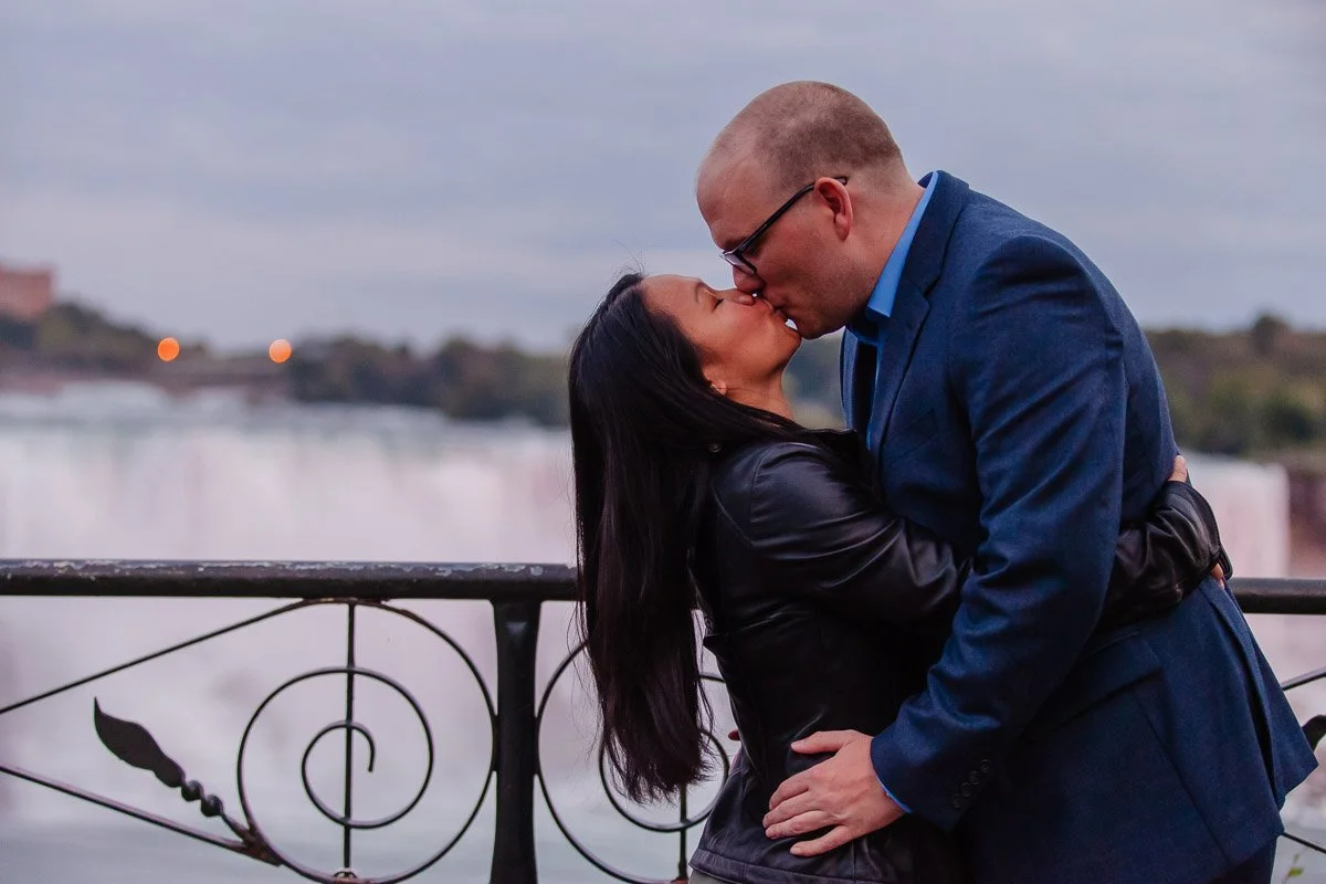 Couple embracing and sharing a kiss at Niagara Falls