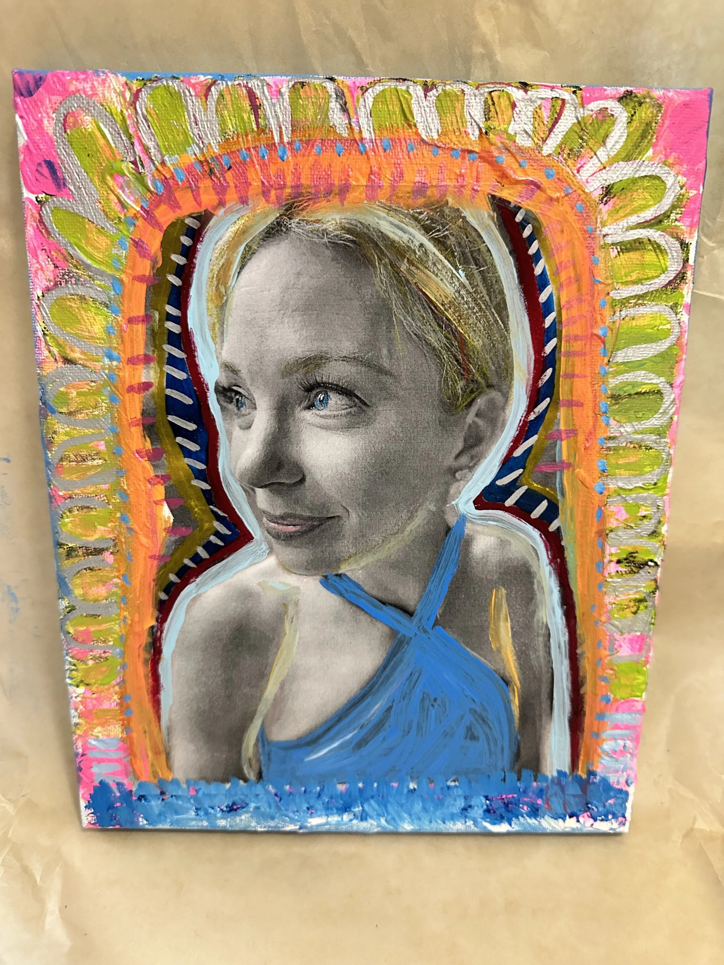 A mixed media portrait combining a black-and-white photograph of a woman with colorful, abstract painted borders and details. The woman has light hair and is wearing a blue top.
