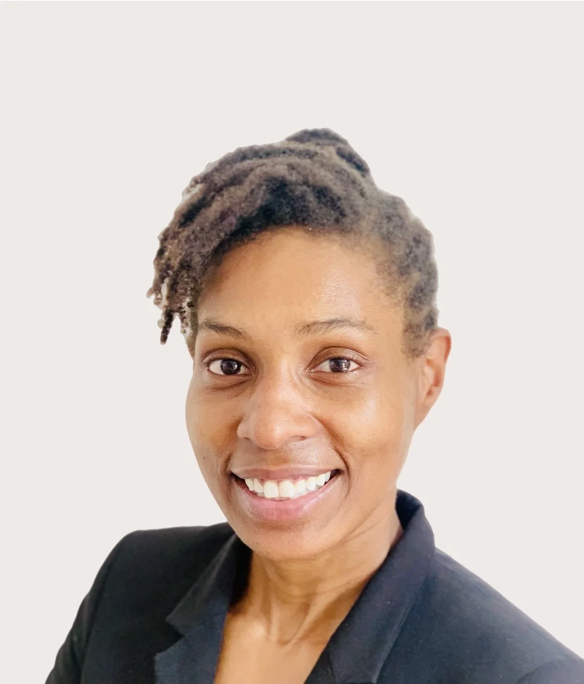 Smiling Dr. Asha Gipson with short textured hair wearing a black blazer against a plain white background. Addison Leadership Advisory, Dr. Asha Gipson