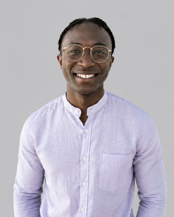 Felix Addison wearing glasses and a light purple button-up shirt, smiling at the camera against a plain light gray background.  Addison Leadership Advisory