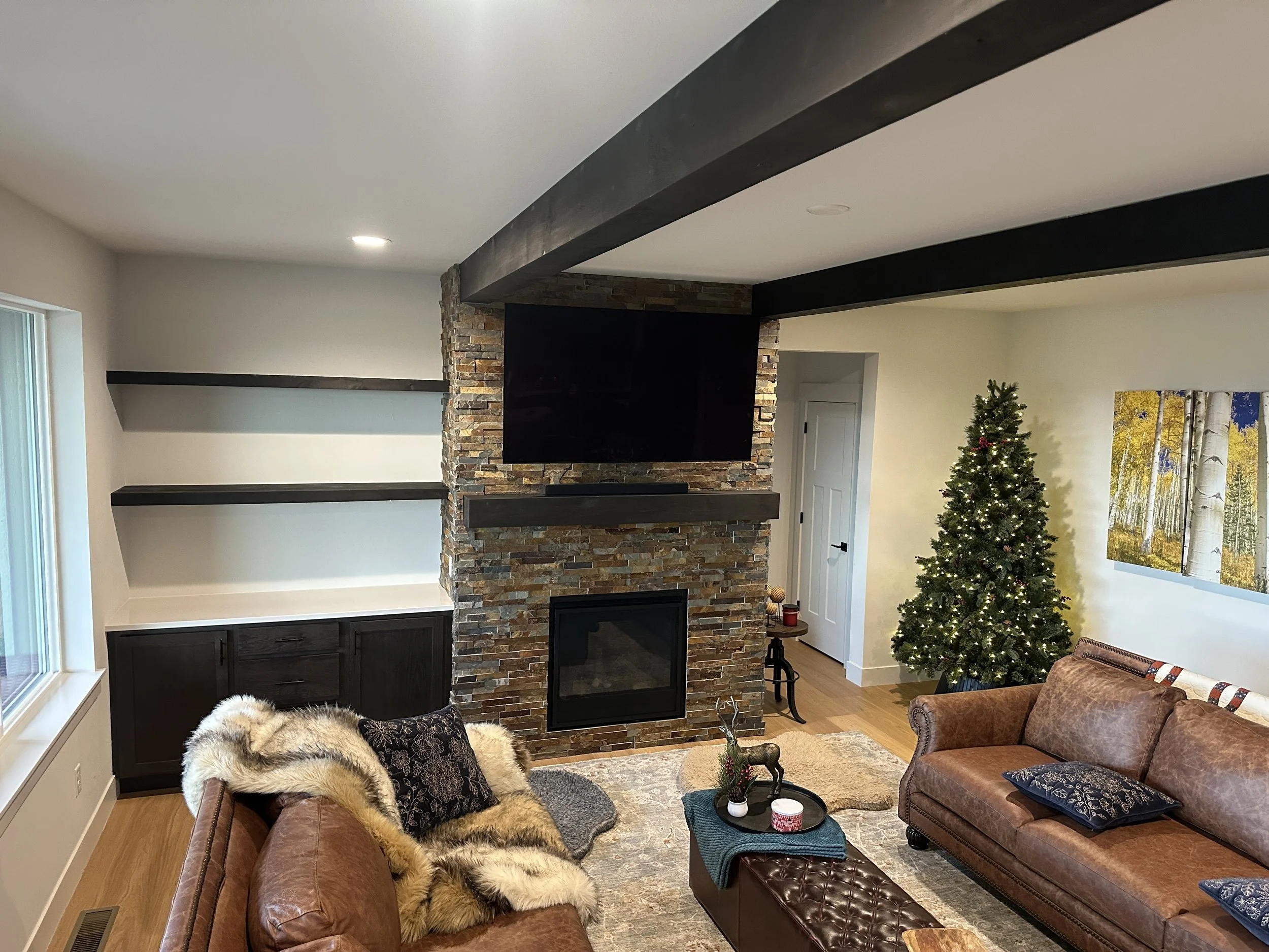 Cabinets, tile fireplace, floating shelves, mantel, and faux beams