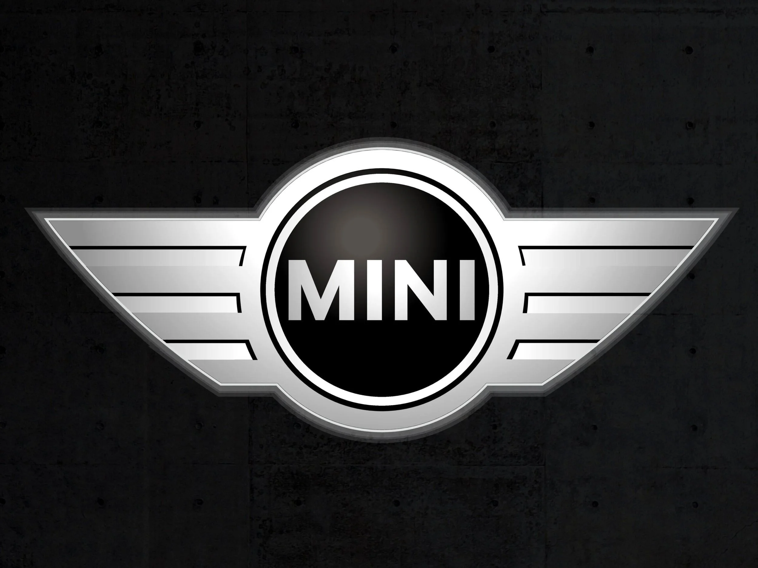 Neon sign of the MINI logo with black background, featuring white circular emblem with the word MINI in the center and horizontal stripes on each side.