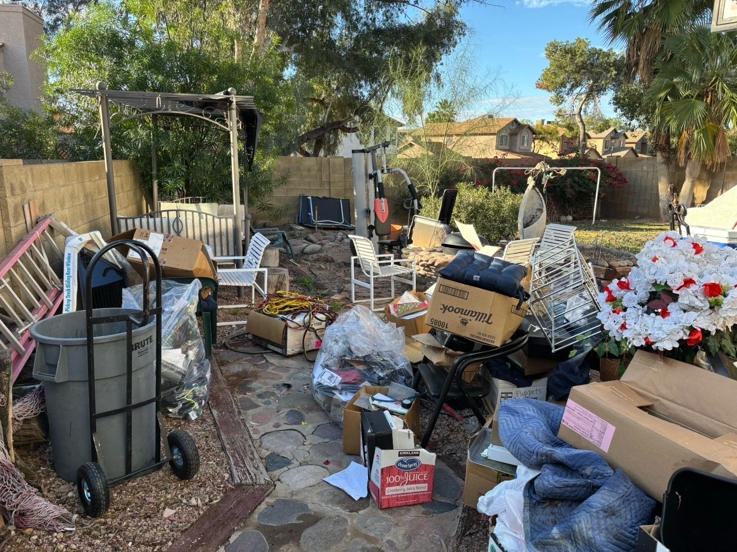 Messy backyard full of scattered boxes and household items before yard cleanup and junk removal in Scottsdale