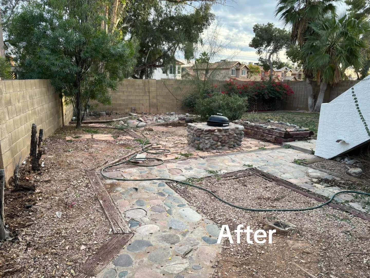 Cleared backyard with new stone patio and firepit after junk removal and yard cleanup in Phoenix
