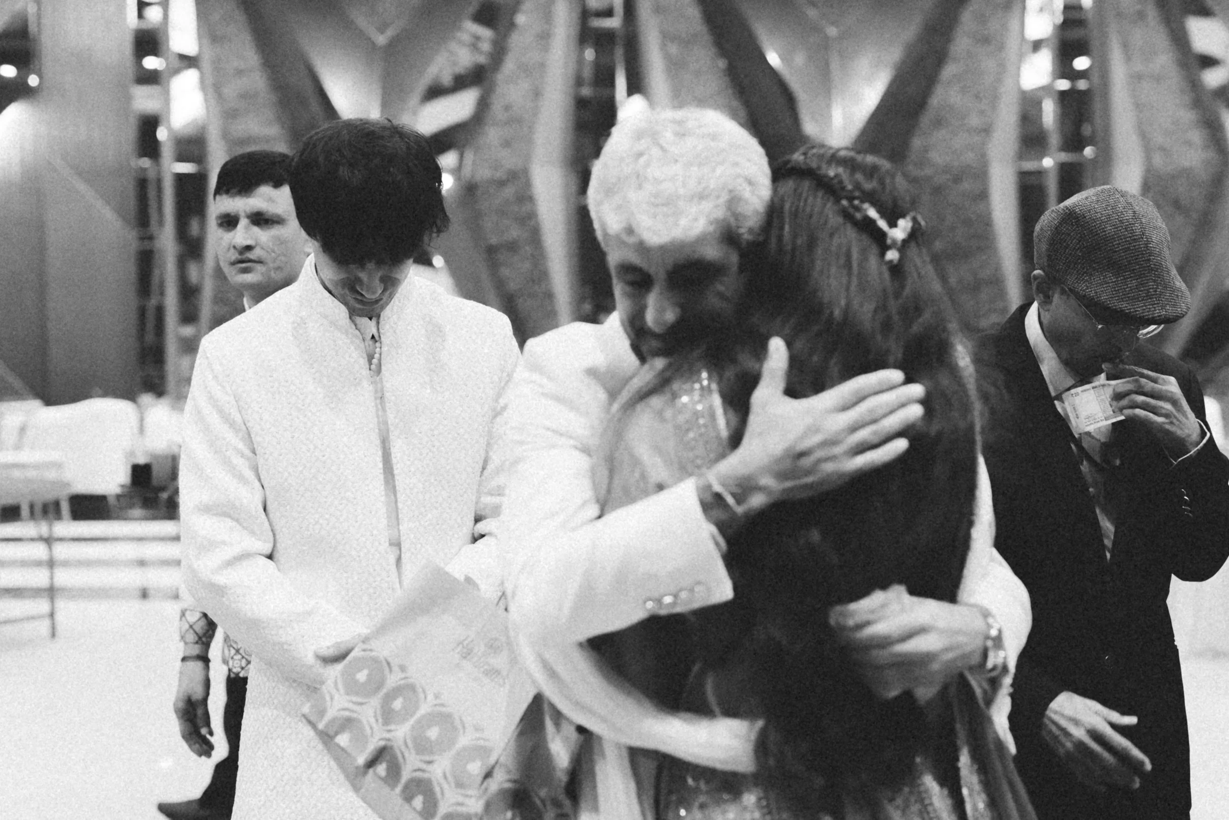 People embracing and exchanging gifts in an indoor setting.
