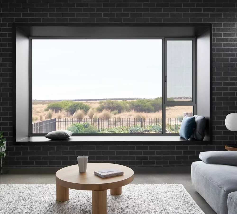 Large aluminum window overlooking a field and fence