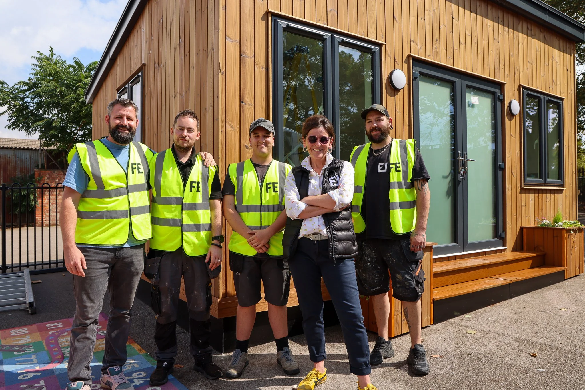 The Foundry Education team posing proudly in front of a modular classroom.
