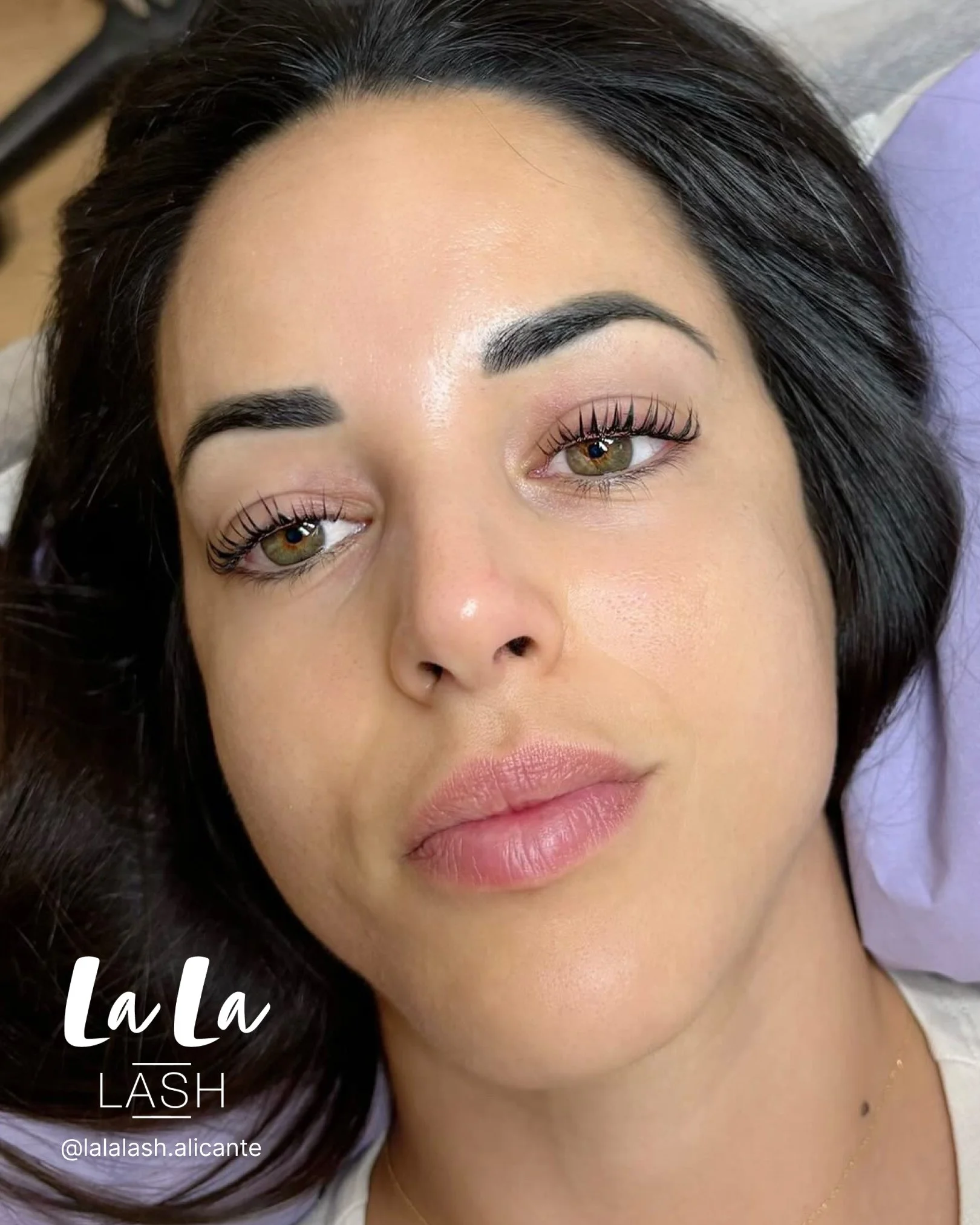 Mujer con maquillaje de ojos, cejas bien definidas, cabello oscuro y liso, rostro visible, fondo difuso.