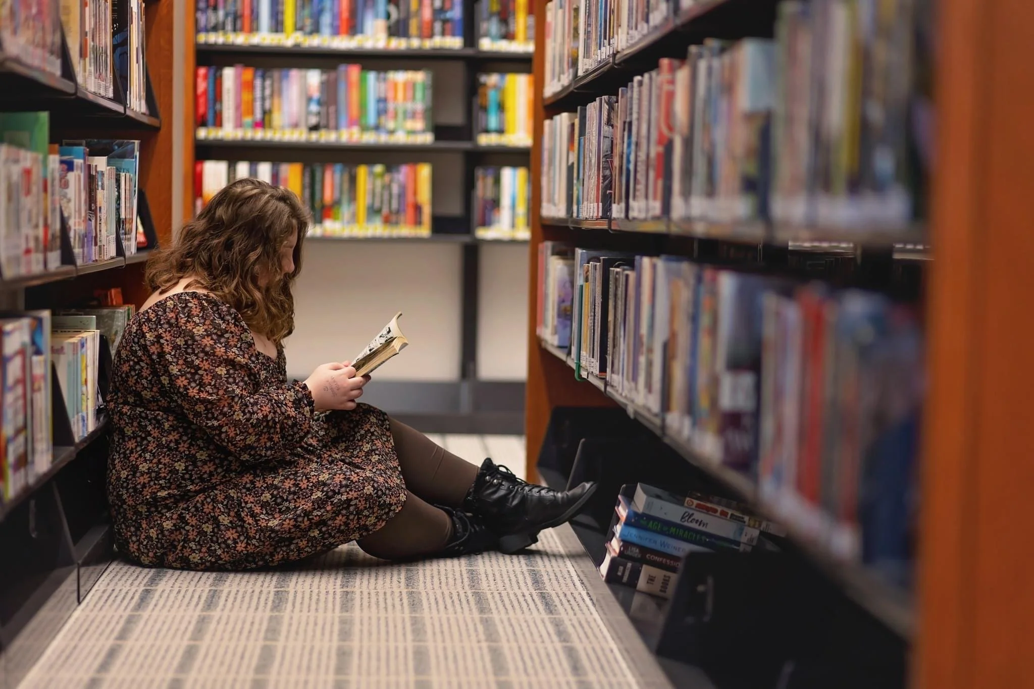 Aleah reading a book in a library