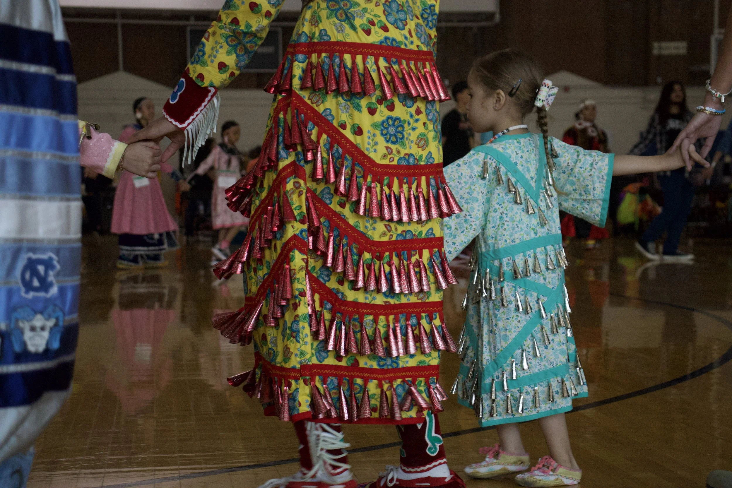 Children of Symone McBride hold hands during a community dance open to all attendees at the Carolina Indian Circle Pow Wow at the University of North Carolina at Chapel Hill on March 7th, 2026.