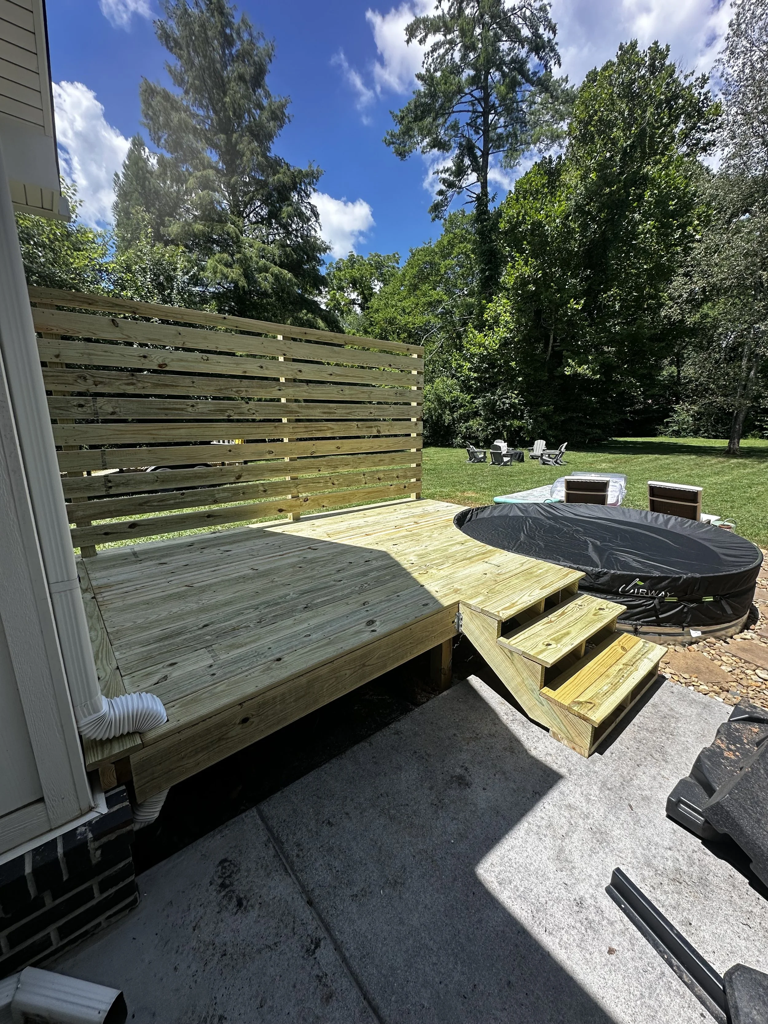 Backyard patio with a newly built pressure treated wooden deck in Powell, TN
