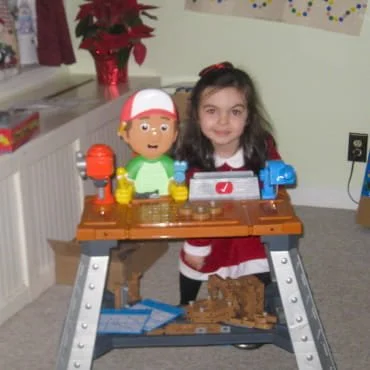4-year-old Chelsea poses behind her Handy Manny construction set toy.