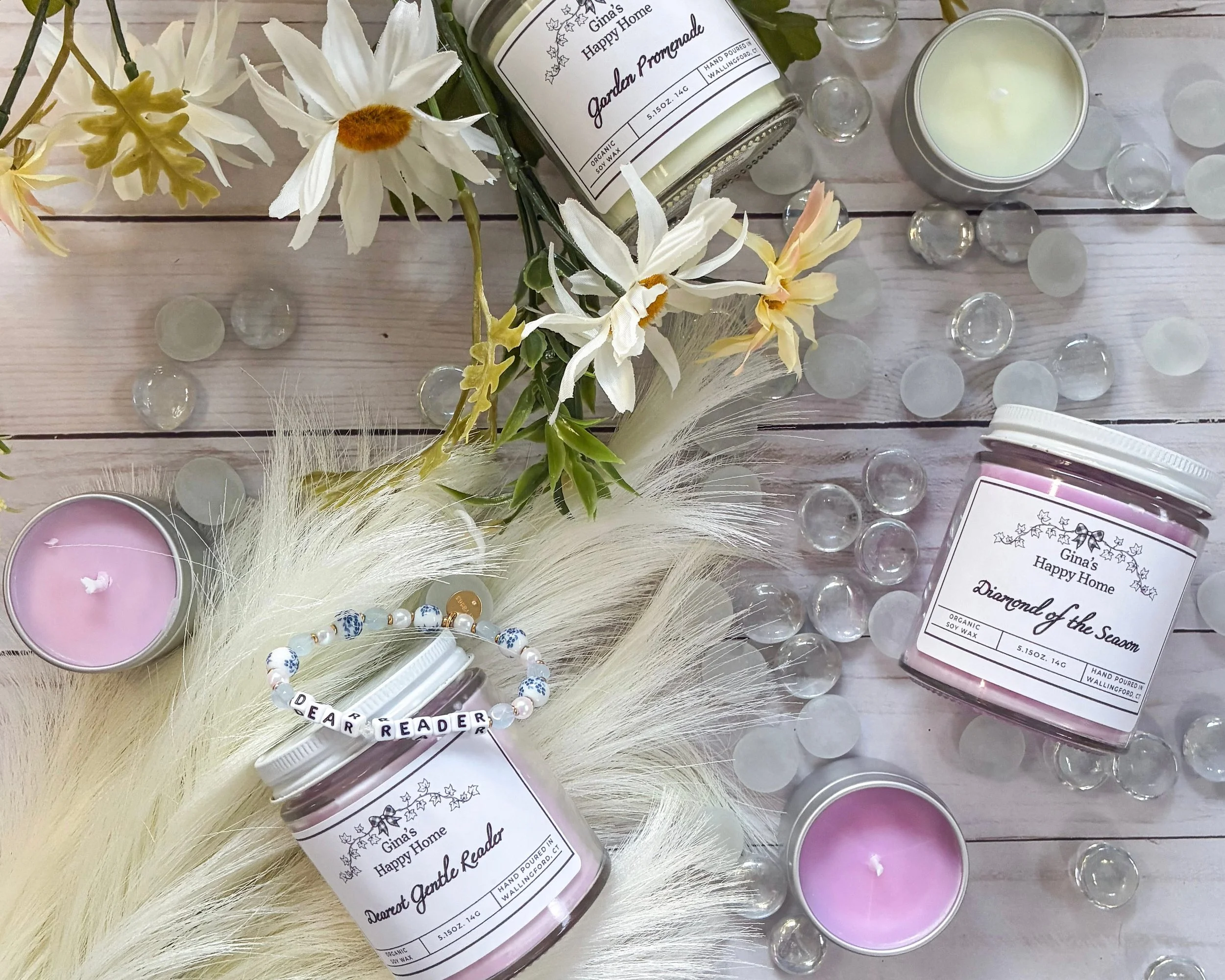A flatlay showcases some Bridgerton themed candles with floral decor. 