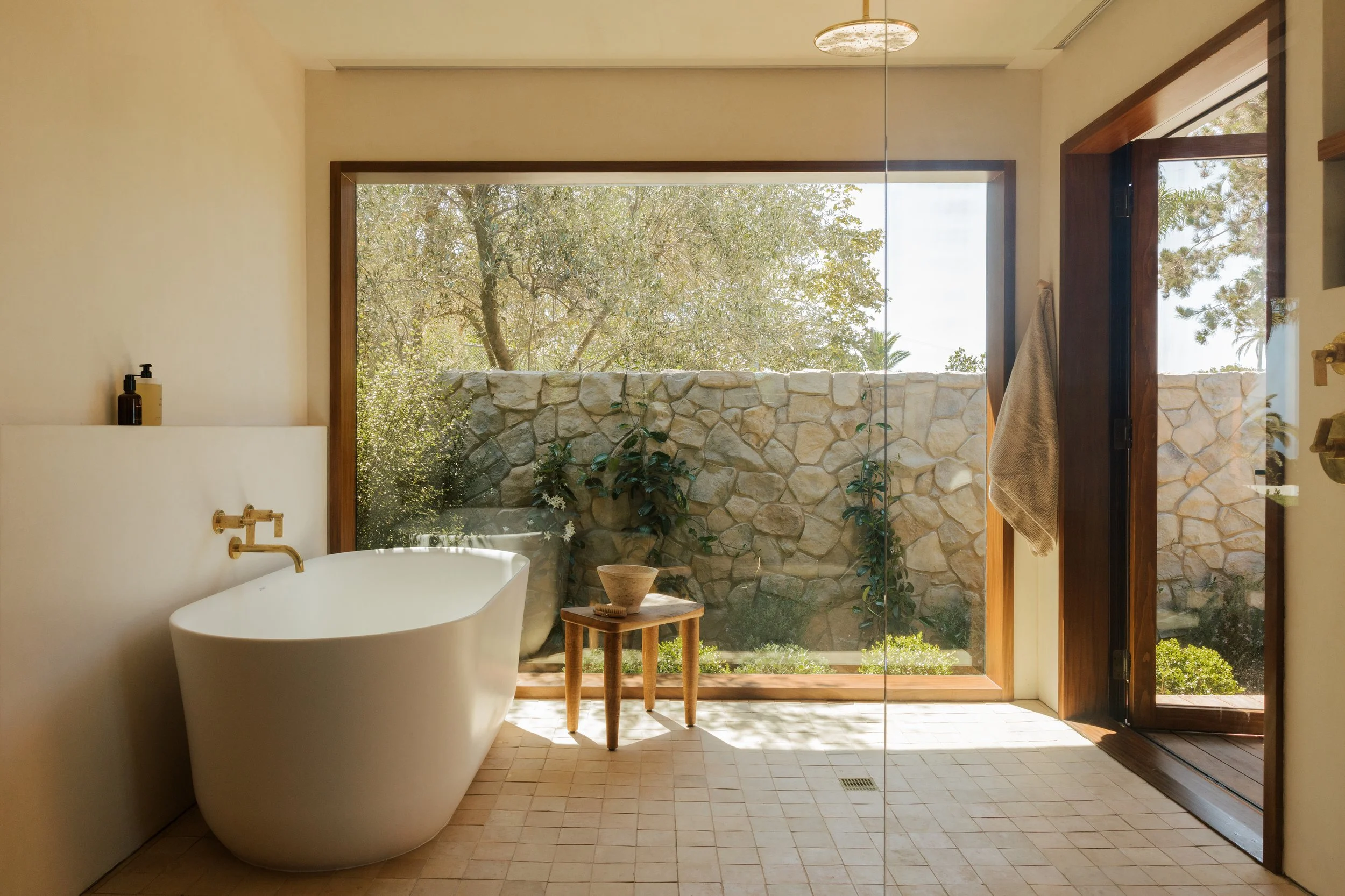 Primary bathroom with freestanding tub and garden views