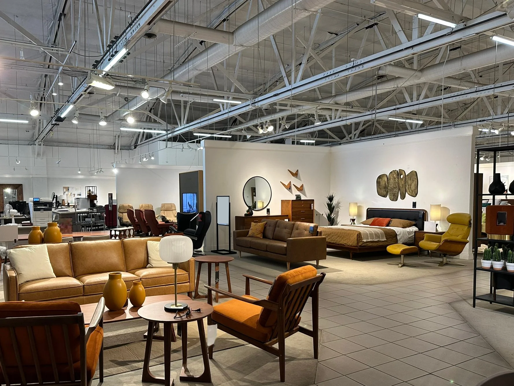 Exposed bow-truss warehouse interior. Earlier furnished condition shown; the space will be empty and unfurnished.
