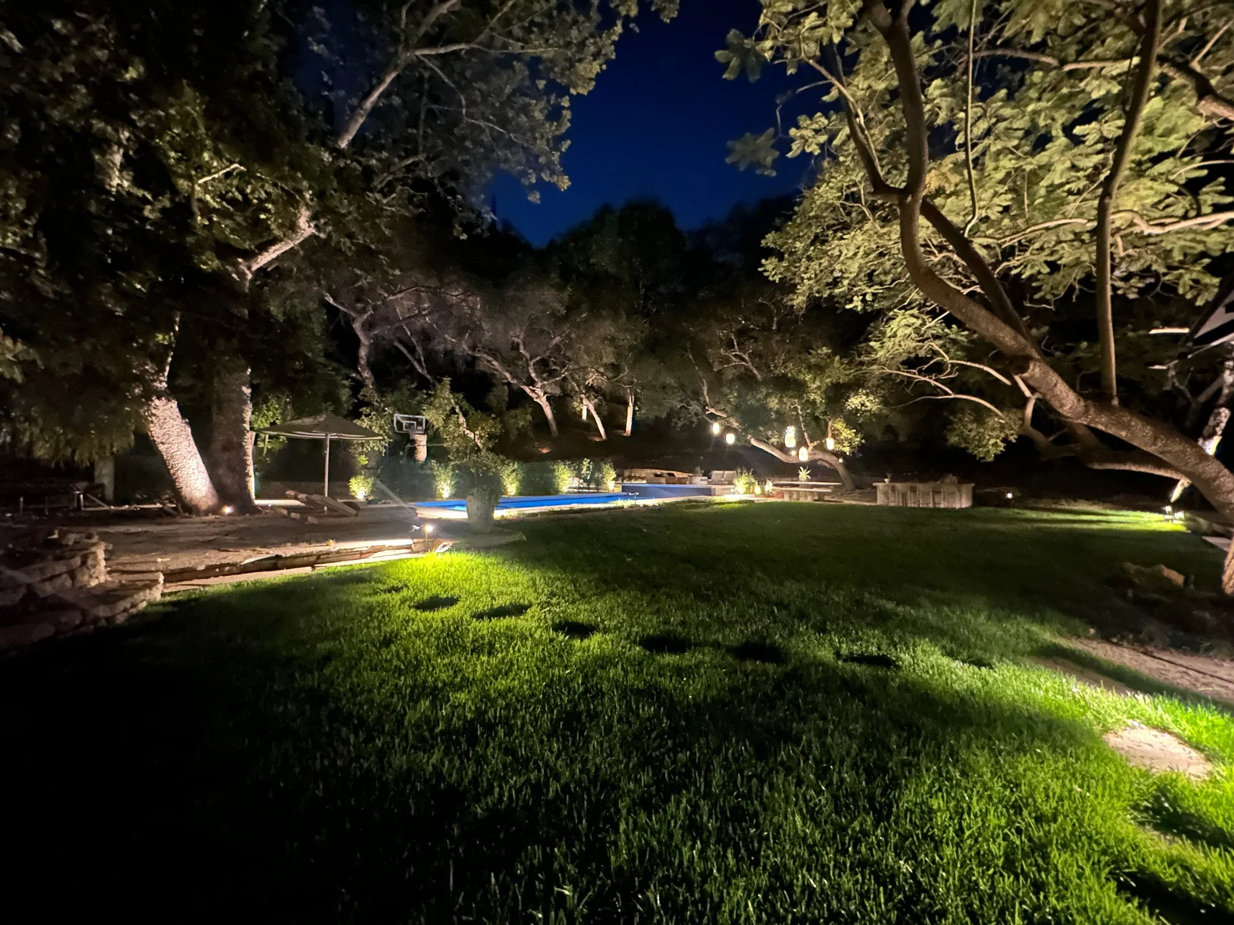 Night view across the lawn and illuminated pool. | PL-3803