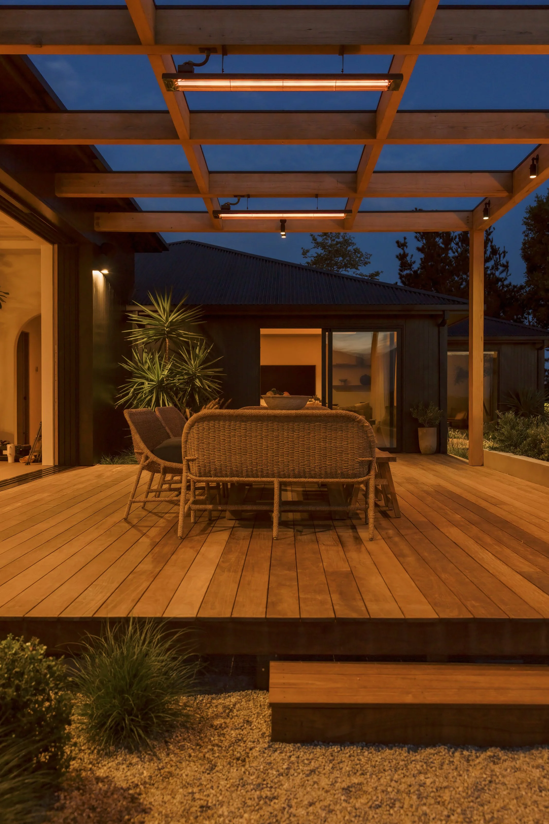 Dining terrace with illuminated bedroom beyond