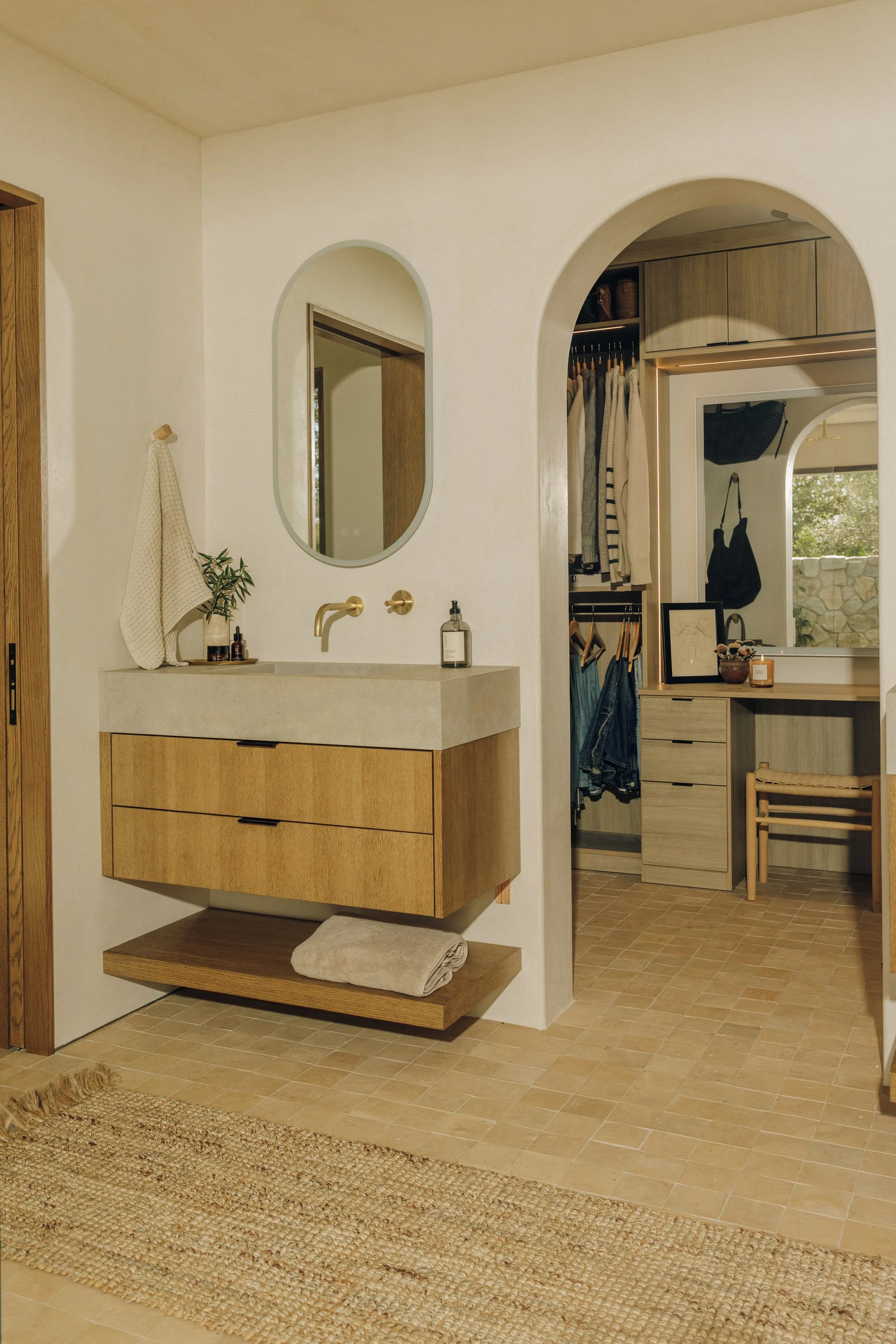 Primary bathroom vanity and arched dressing-room doorway