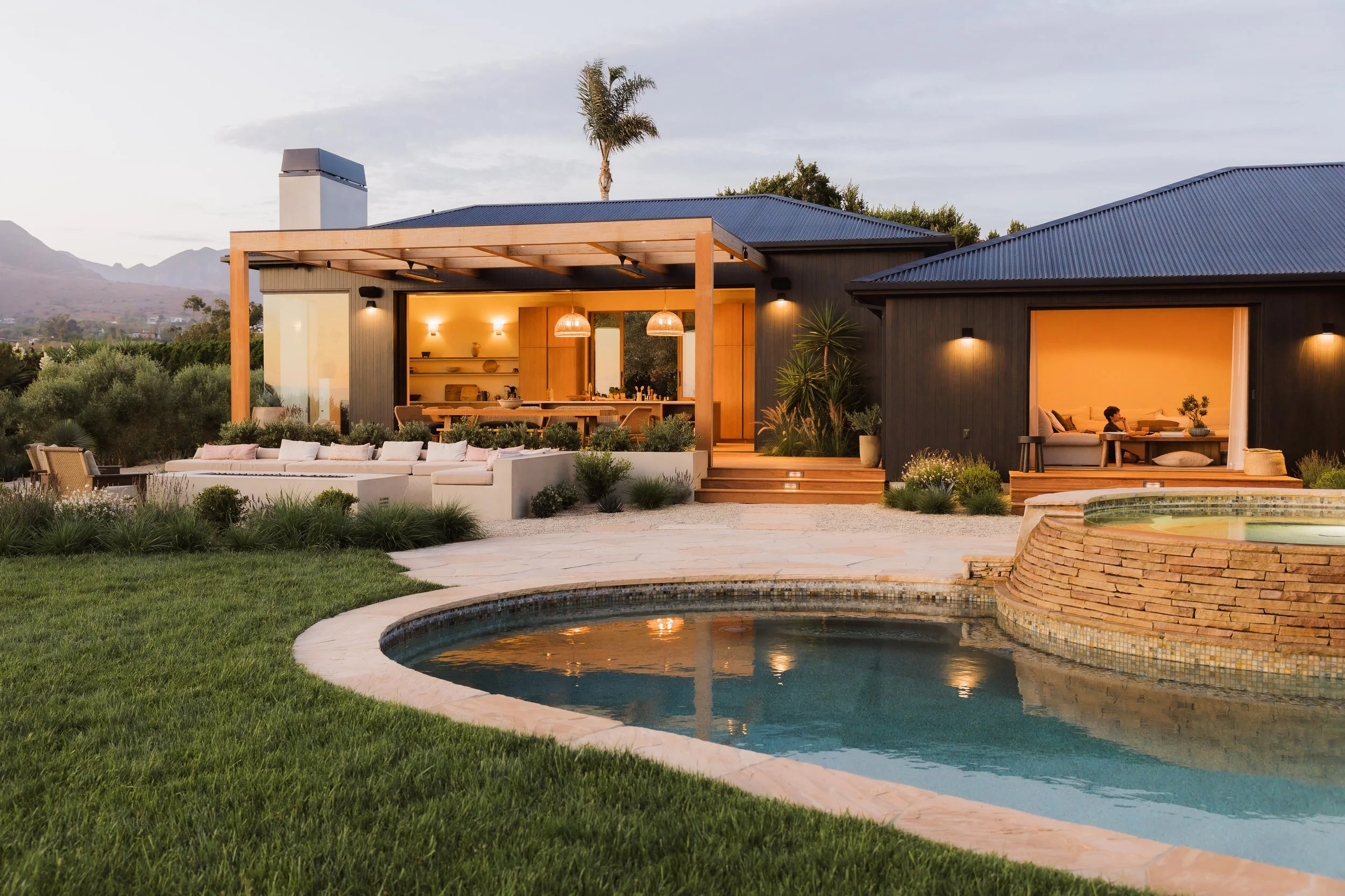 Poolside lawn and illuminated house