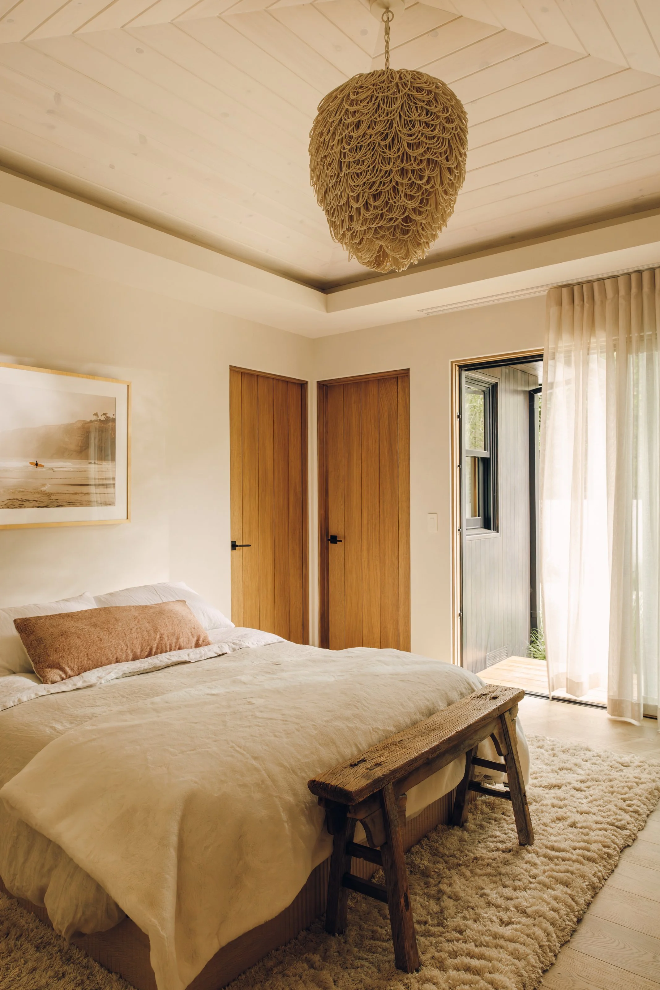 Guest bedroom with vaulted ceiling and neutral bedding