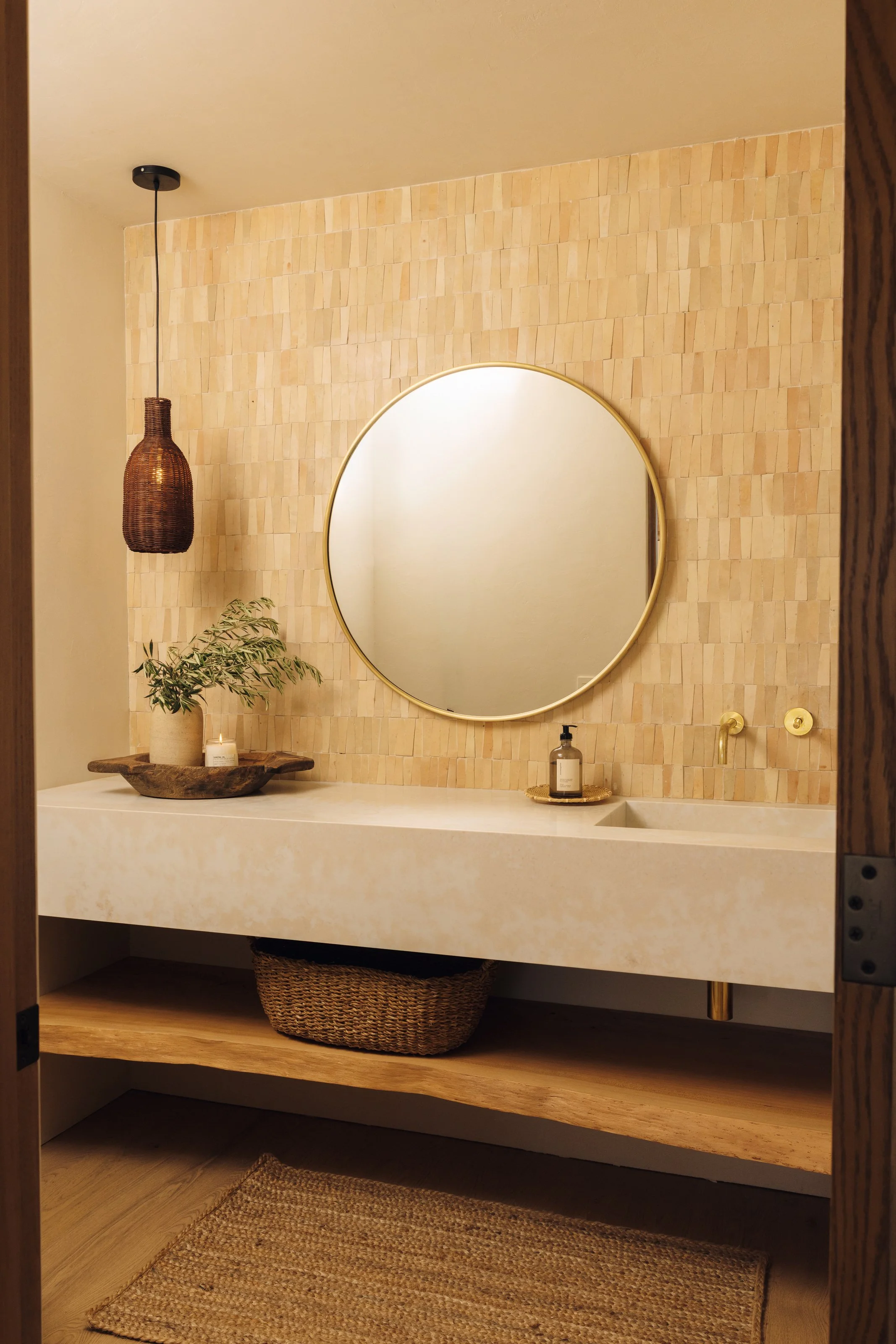 Powder room with floating vanity and round mirror