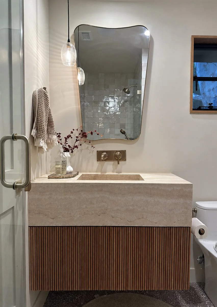 Guest bathroom with stone vanity and glass shower. | PL-3803