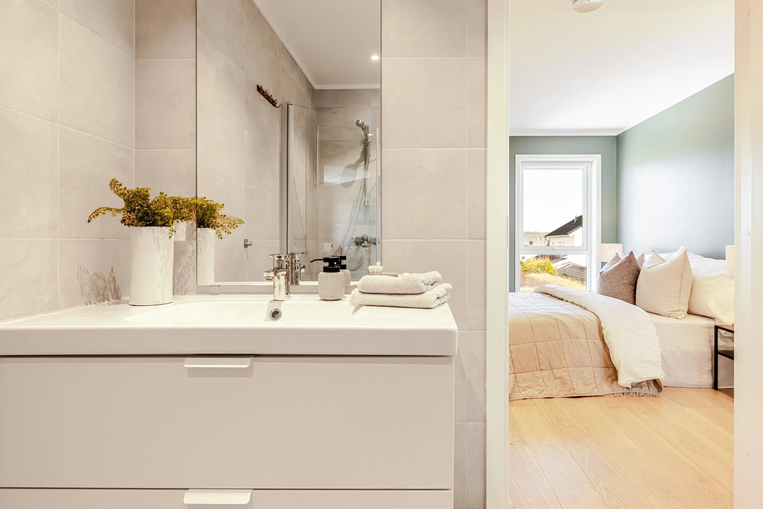 To personer som håndhilser mot bakgrunn av en uklar, nøytral vegg.