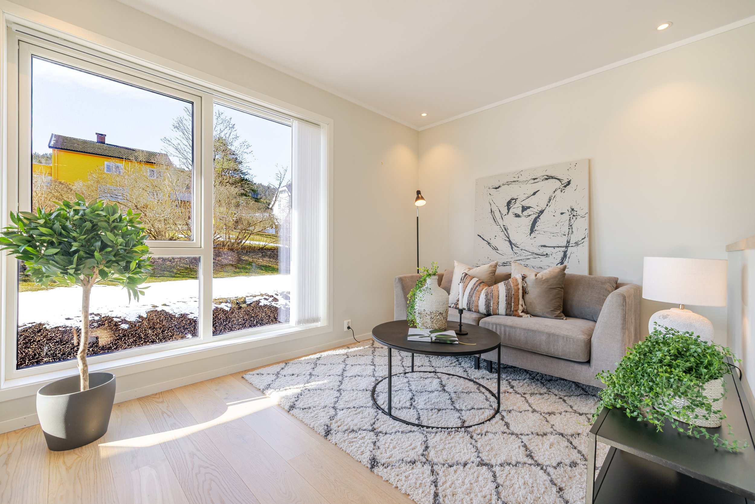 Person som viser ulike tekstiler og keramikkprøver på et treskrivebord