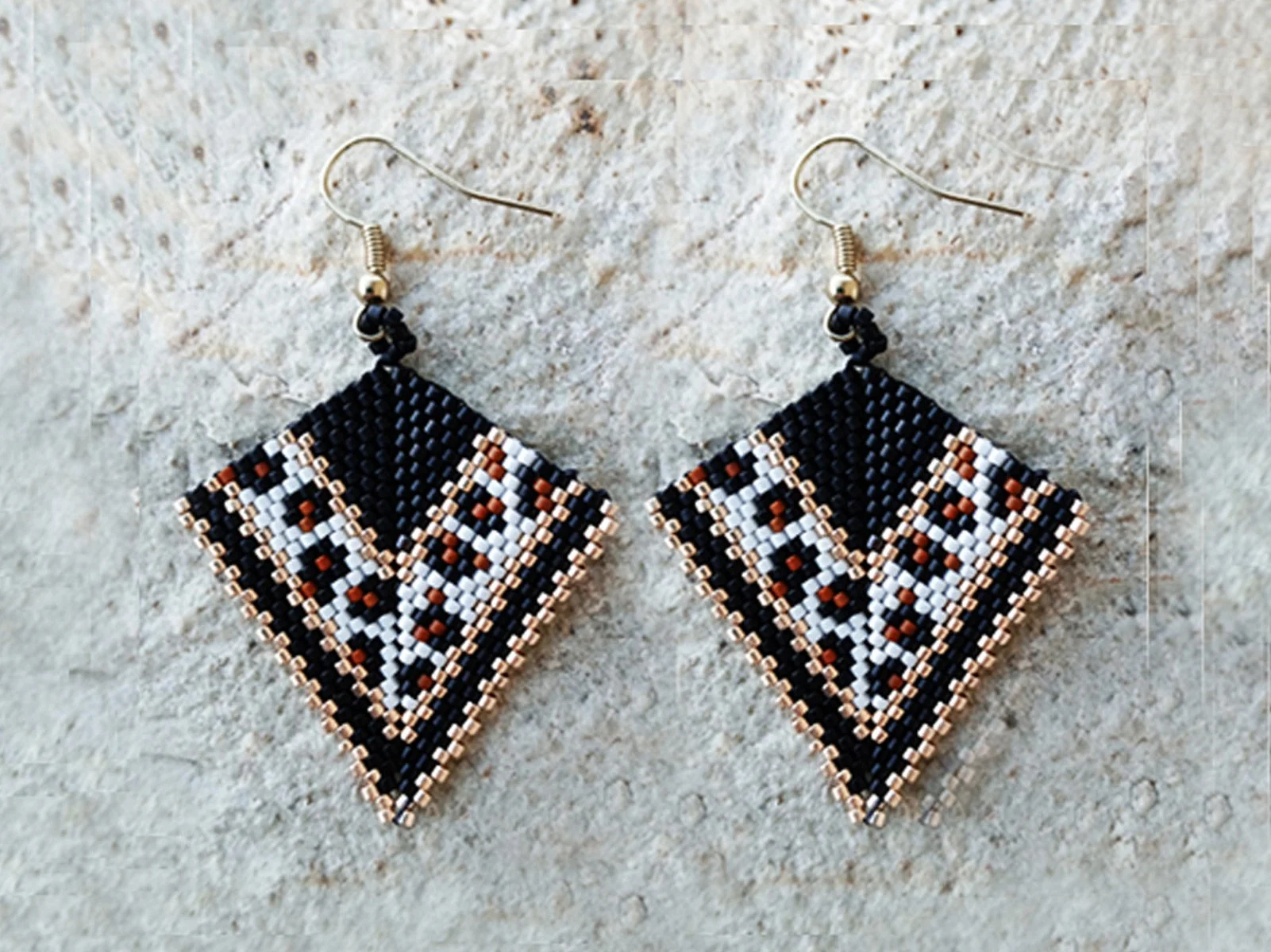 Handmade geometric arrow-shaped beaded earrings in peyote stitch and handwoven in a chic animal print jaguar pattern with metallic gold accents.