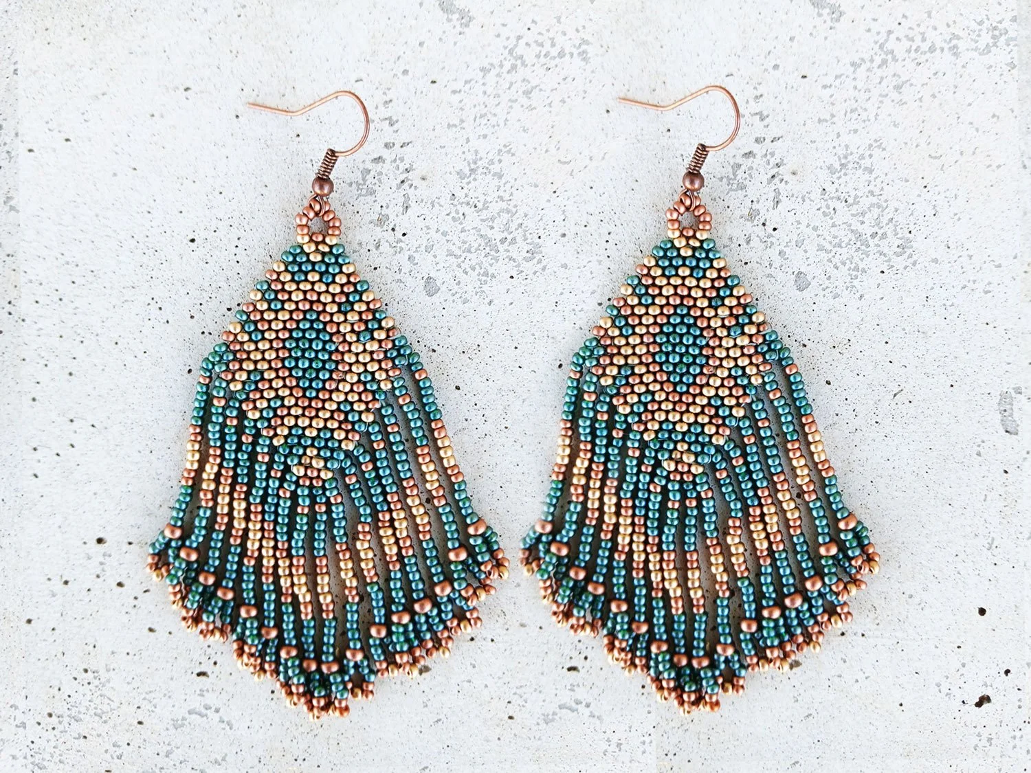 Handmade Southwestern beaded fringe dangle earrings handwoven in an earthy green, metallic gold, and copper color palette.
